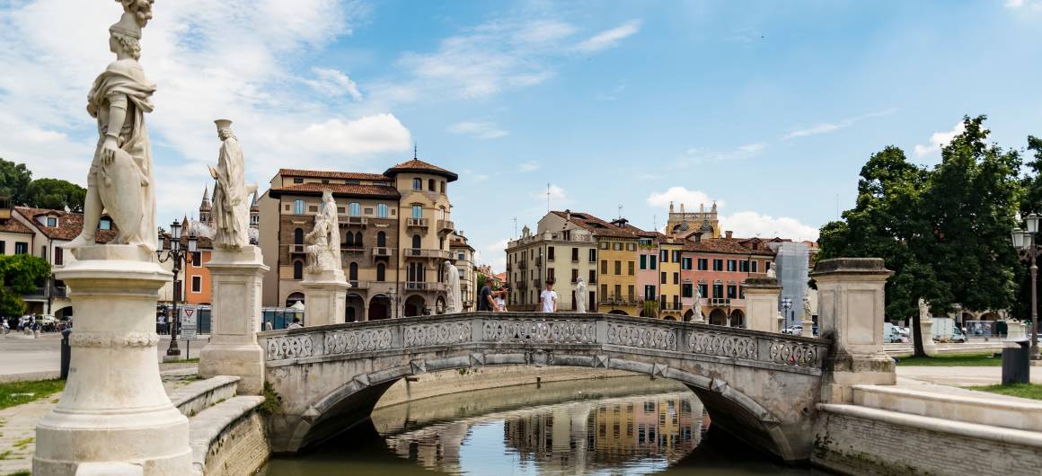 Marble statues on a stone bridge crossing the canal at Prato della Valle in Padua.