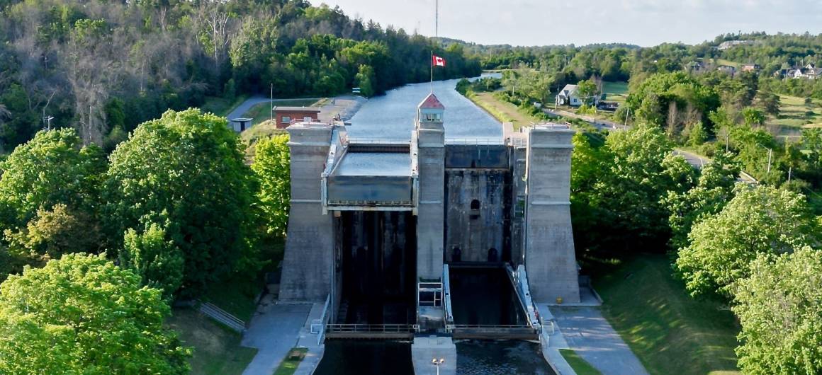 Vista aérea de la esclusa-ascensor de Peterborough en el Trent‑Severn en Ontario, rodeado de vegetación y bajo cielos despejados en un día de verano.
