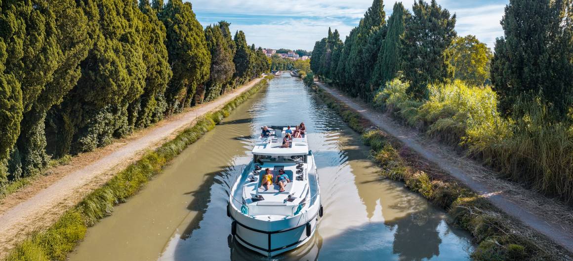 A canal boat cruises the scenic Canal du Midi along the Canal du Midi, offering a relaxing way to explore southern France.