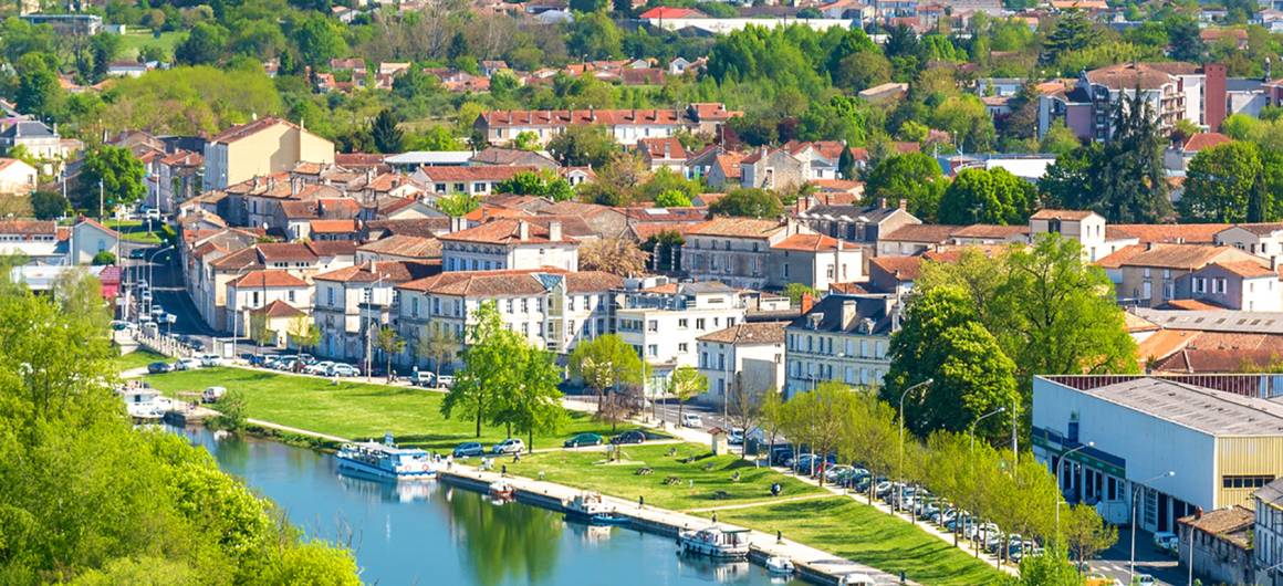 Luchtfoto van Angoulême met boten op de Charente en met bomen omzoomde oevers langs de waterkant.