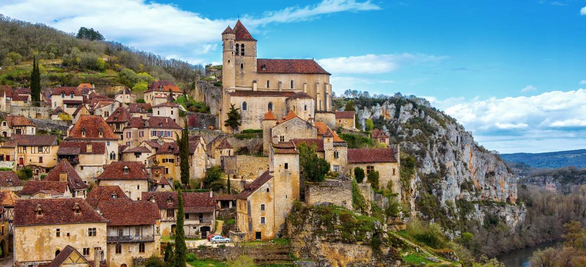 View of the medieval village of Saint-Cirq-Lapopie perched on cliffs above the Lot River.