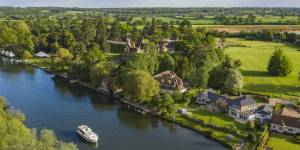 Hooghoekzicht op elegante huizen aan het water langs de Theems, gewild vastgoed aan de rivier.