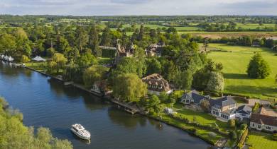 High-angle view of elegant riverside homes along the Thames, sought-after properties on the riverbank.