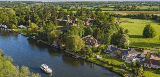 High-angle view of elegant riverside homes along the Thames, desirable property on the banks of the river.