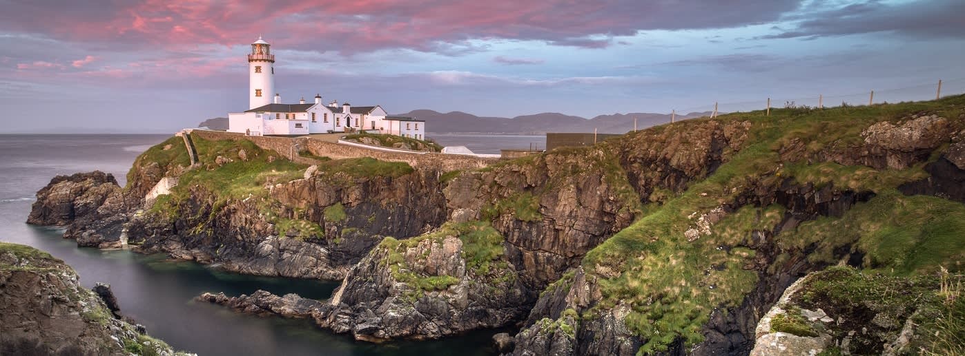 Enchanting Travels UK & Ireland Tours Donegal, Ireland. Fanad head at Donegal, Ireland with lighthouse at sunset. Colorful sky, mountains and sea