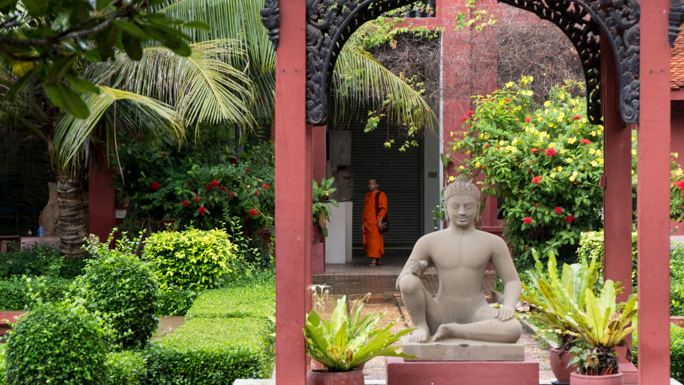 a person sitting on a bench in front of a flower garden
