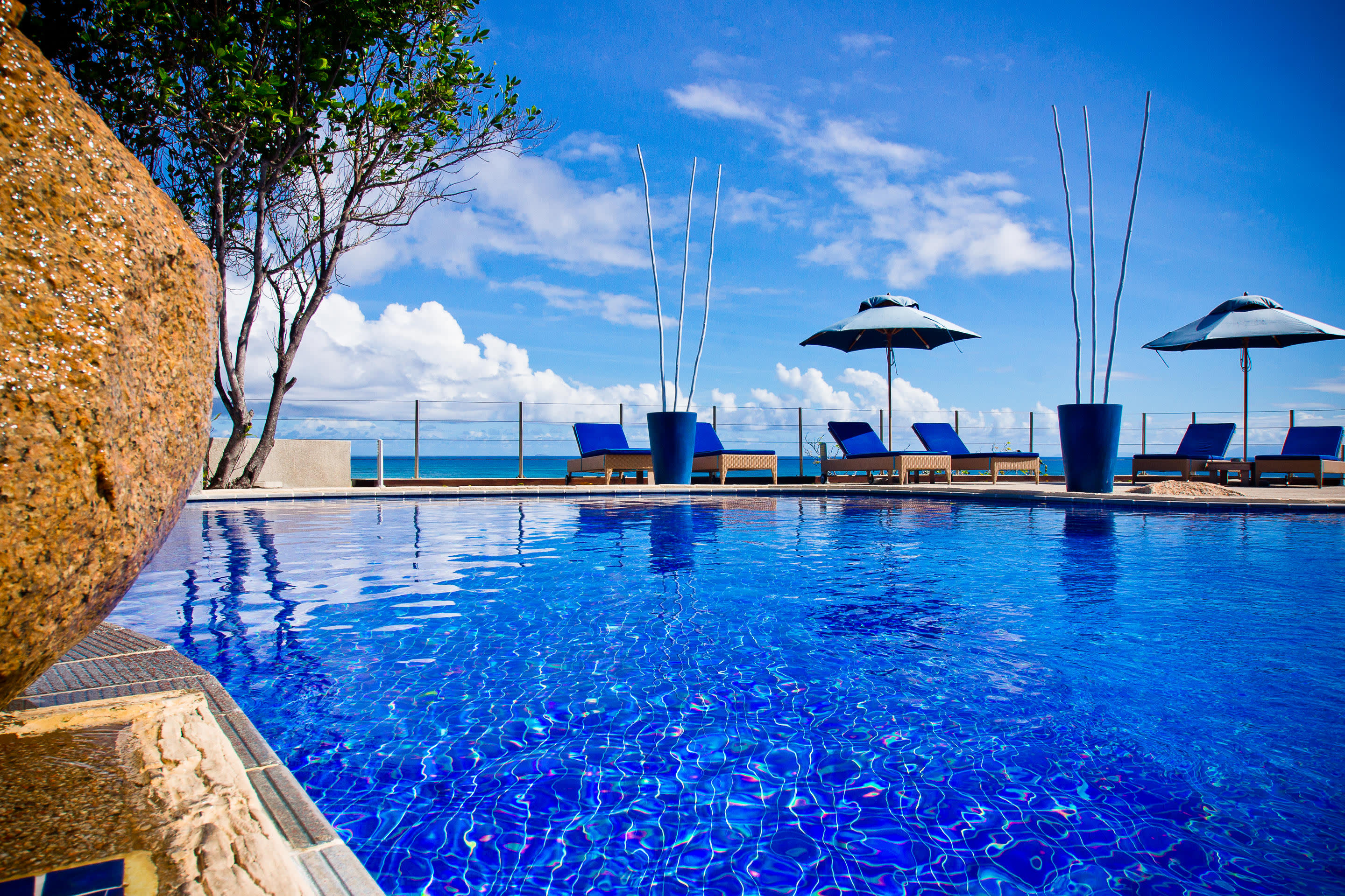 a blue and white boat sitting next to a pool of water