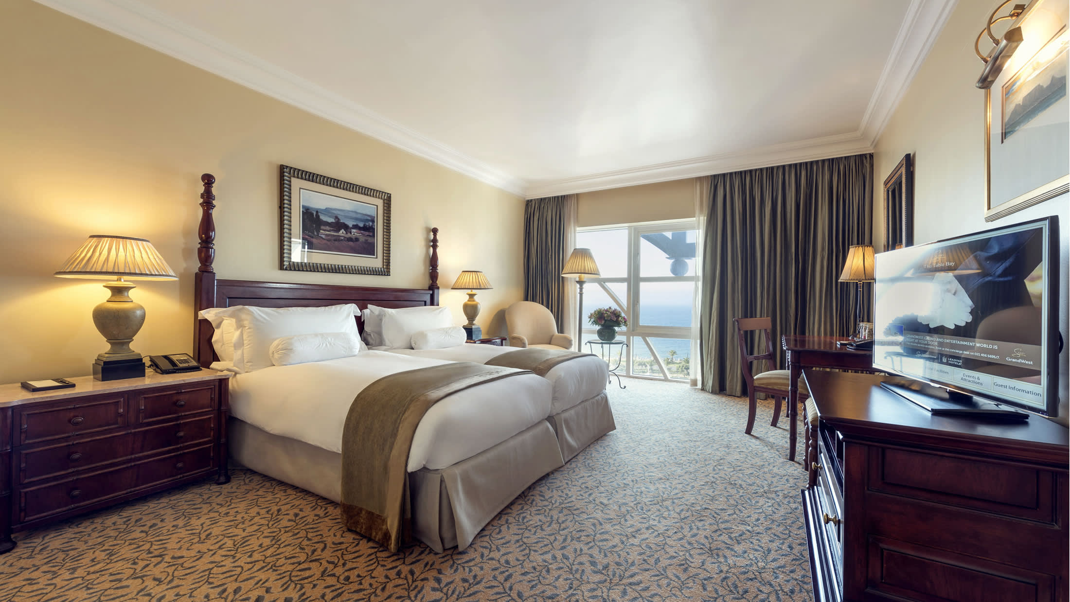 a bedroom with a bed and desk in a hotel room