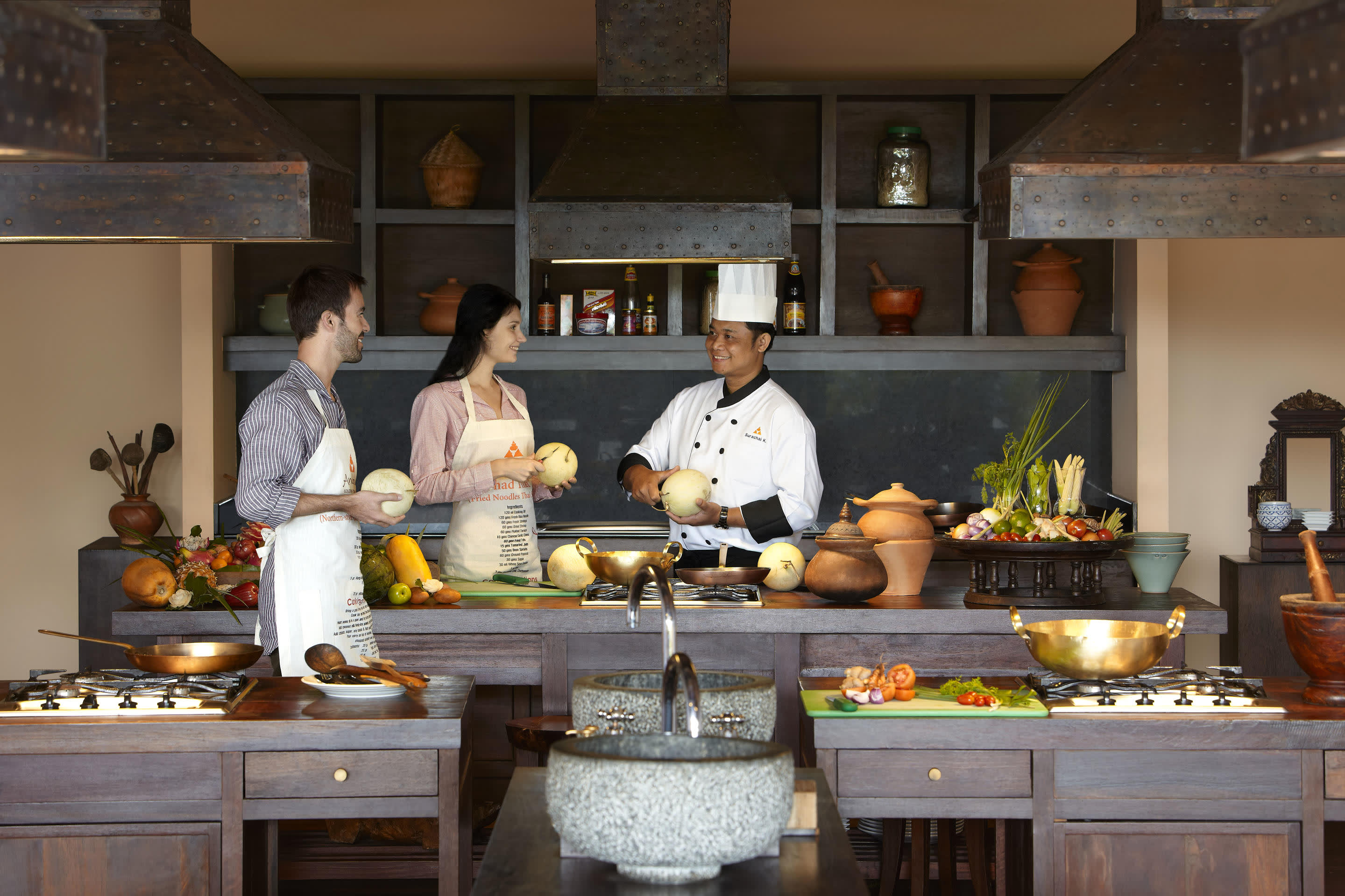 a man and woman cooking food in a kitchen