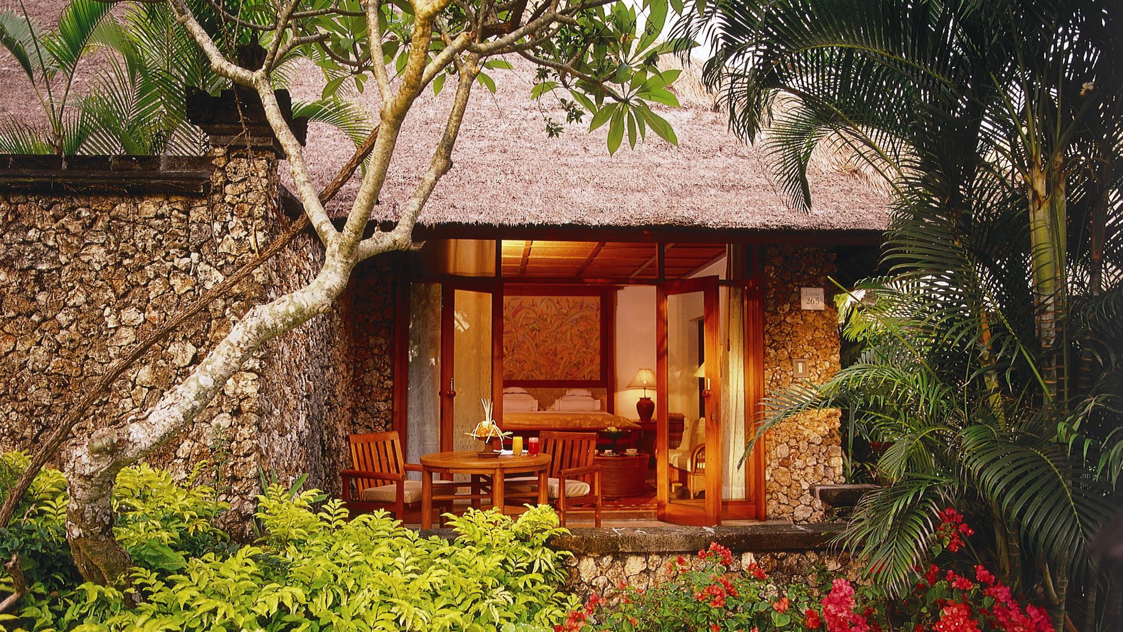 a close up of a flower garden in front of a brick building