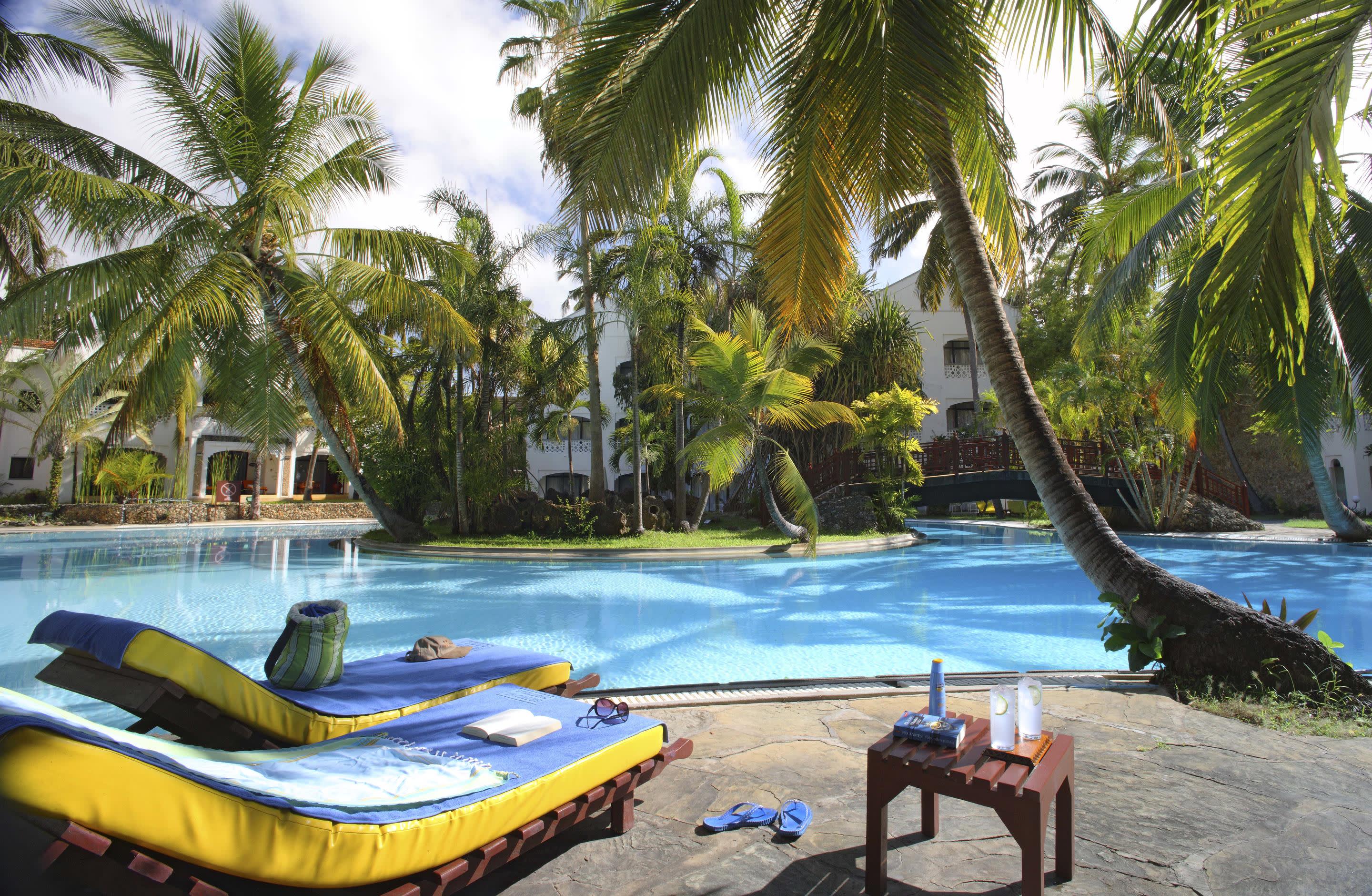 a group of palm trees next to a body of water