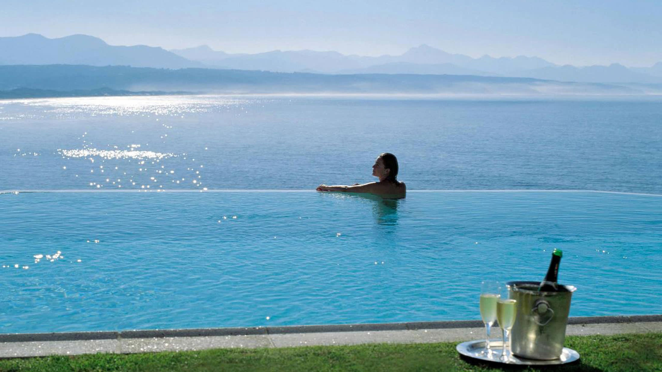 a person sitting next to a body of water next to the ocean