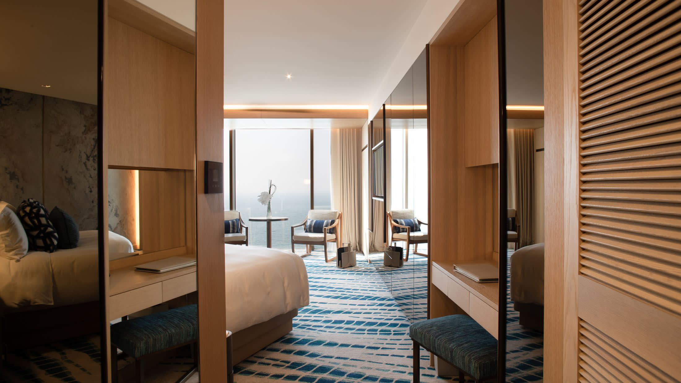 a bedroom with a bed and a chair in a room