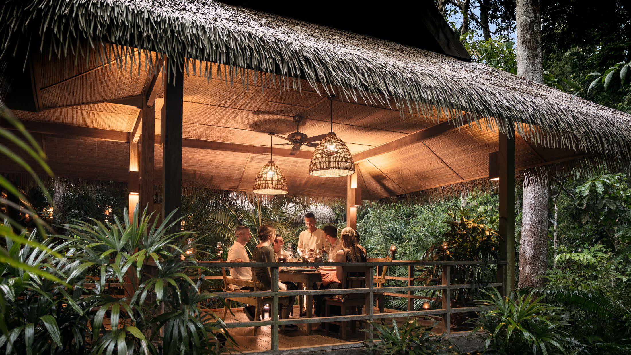 a group of palm trees with a building in the background