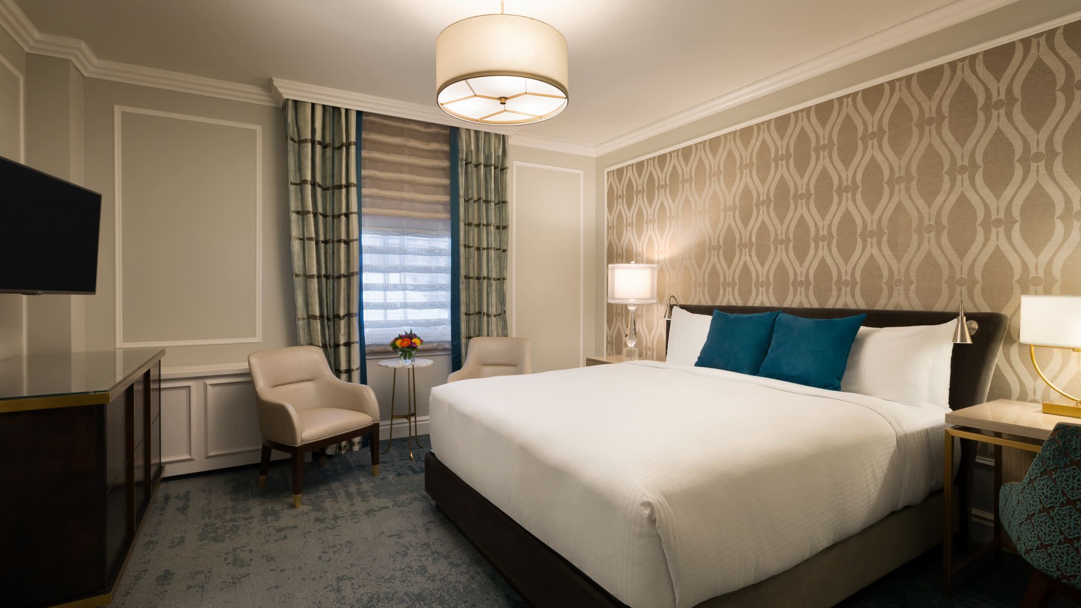 a bedroom with a bed and desk in a hotel room