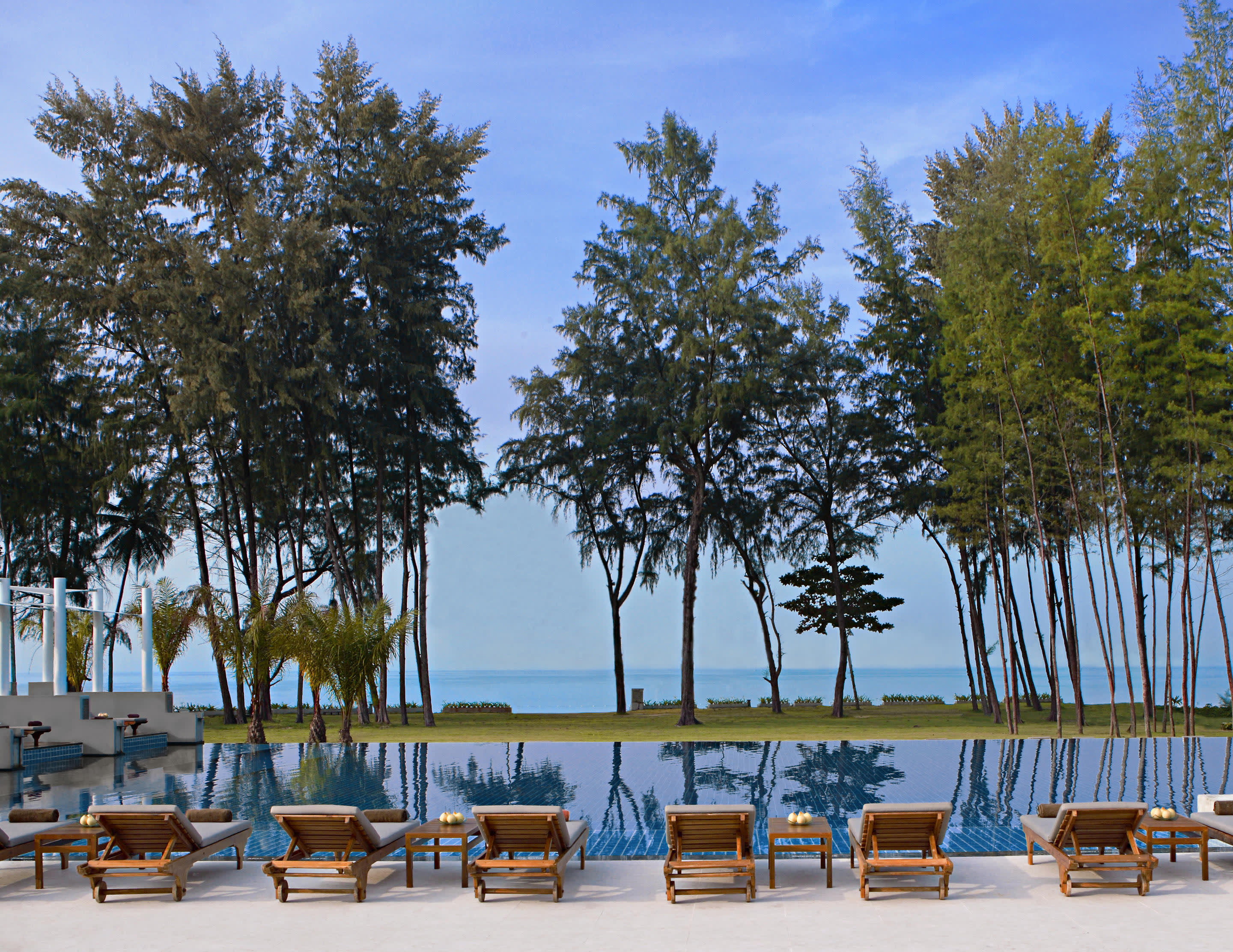 a row of wooden benches sitting on top of a sandy beach