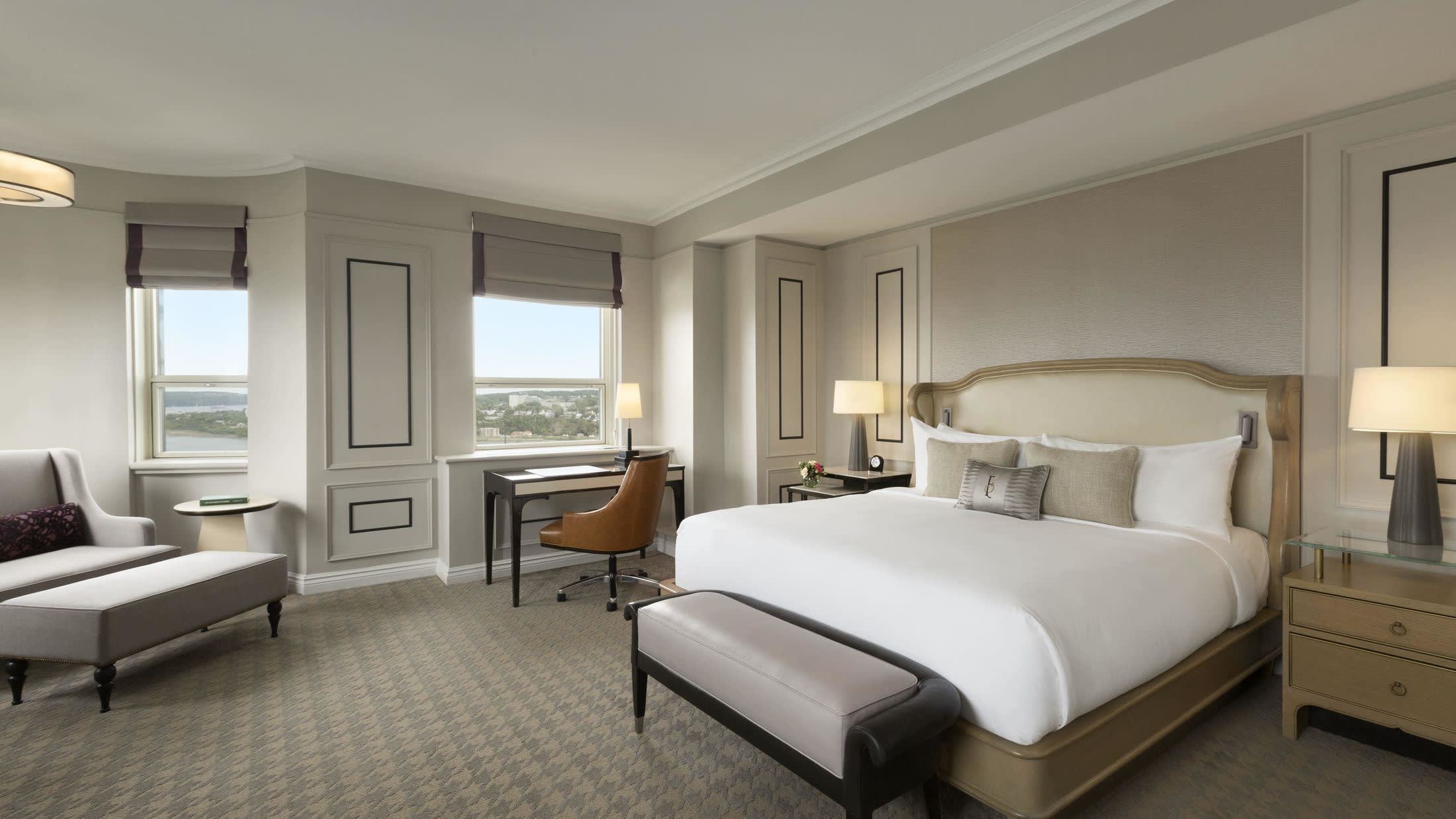 a bedroom with a bed and desk in a hotel room