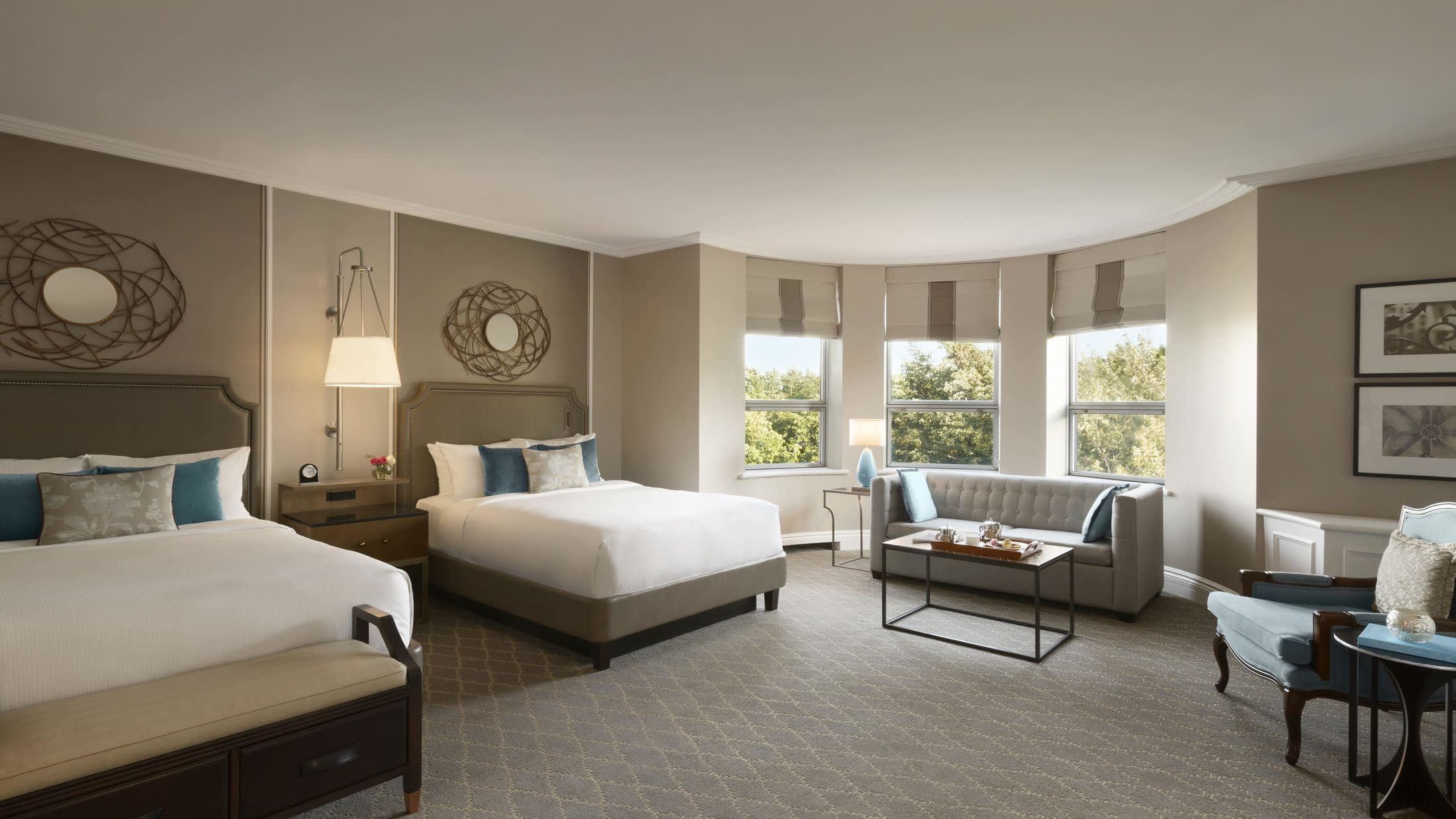 a bedroom with a bed and desk in a hotel room