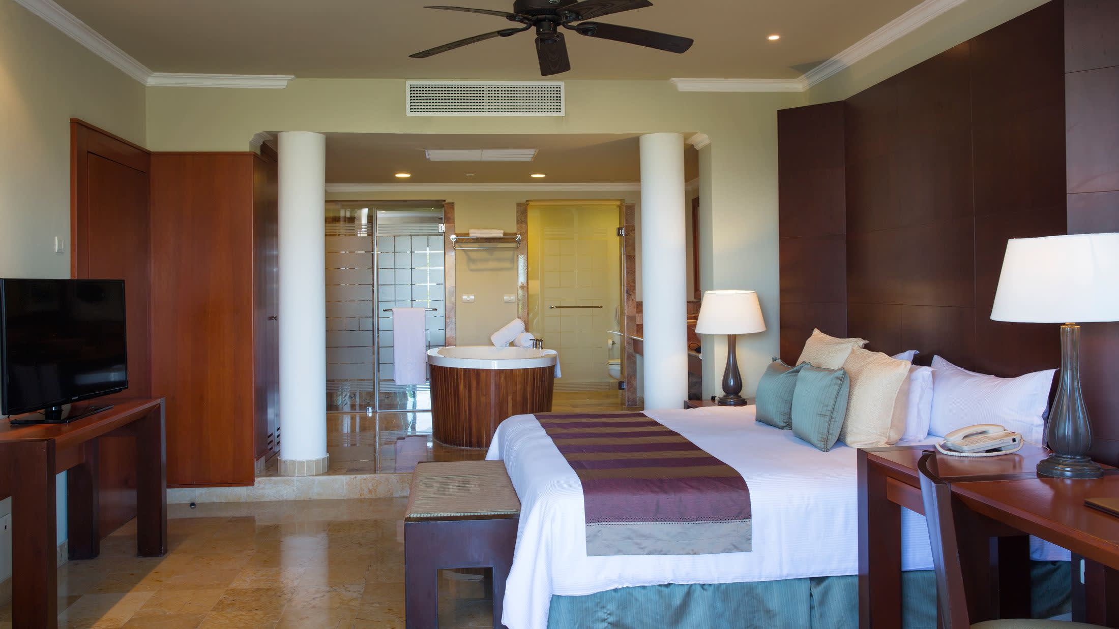 a bedroom with a bed and desk in a hotel room