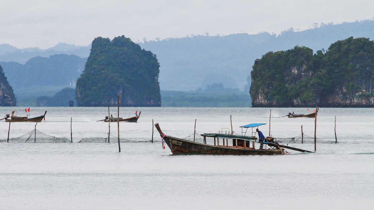 a small boat in a body of water with a mountain in the background
