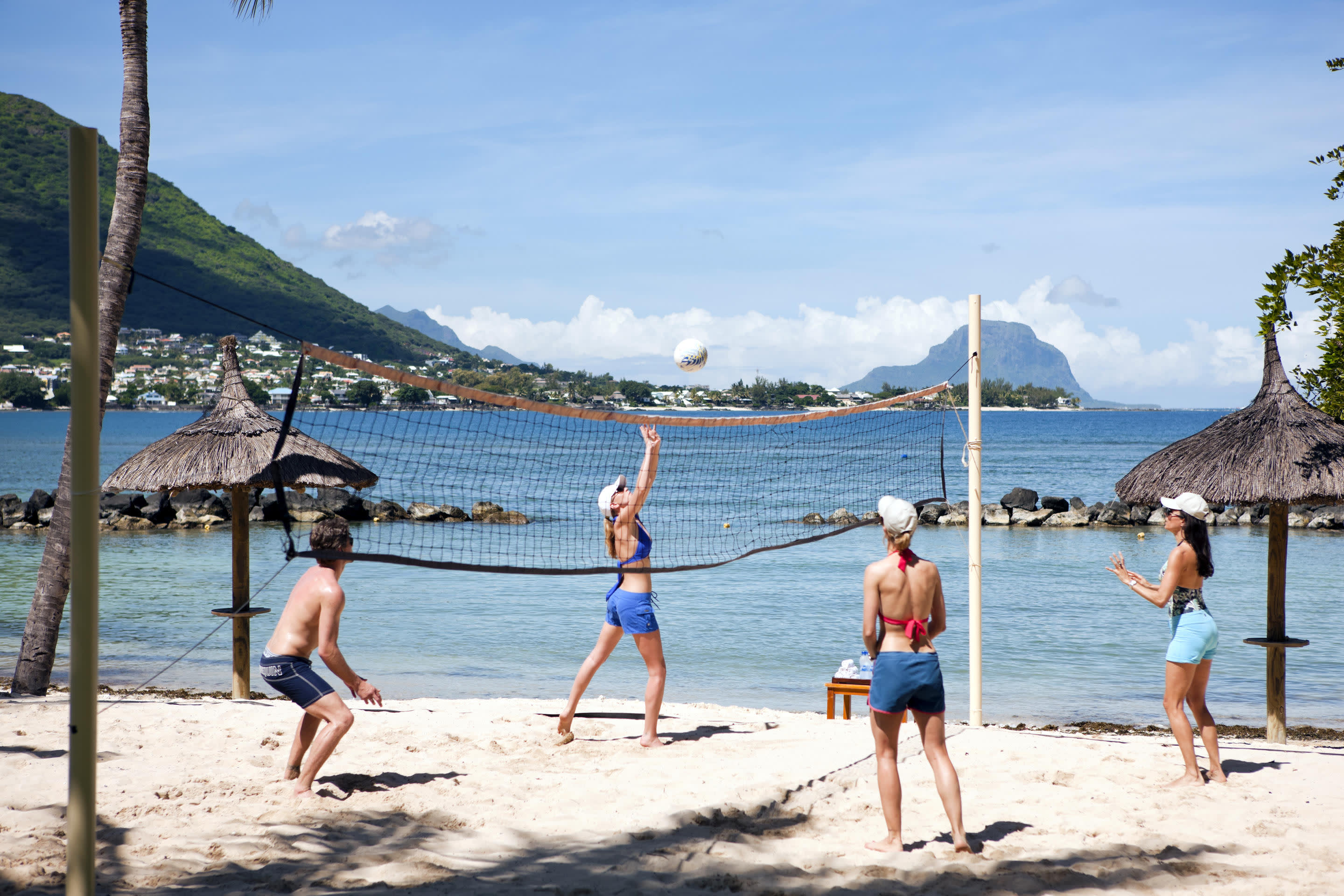 a group of people on a beach in front of a body of water