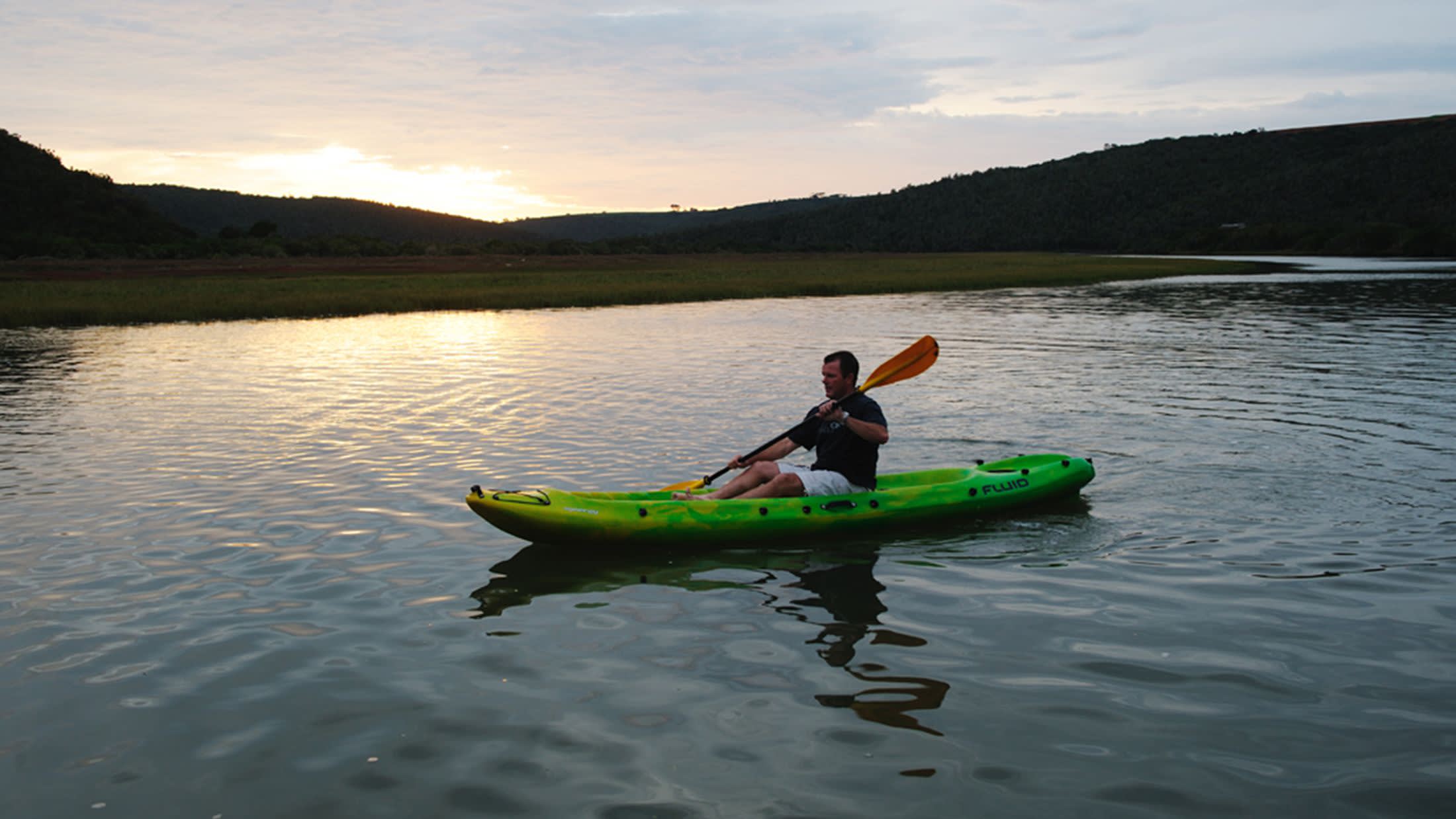 a person in a green boat on a body of water