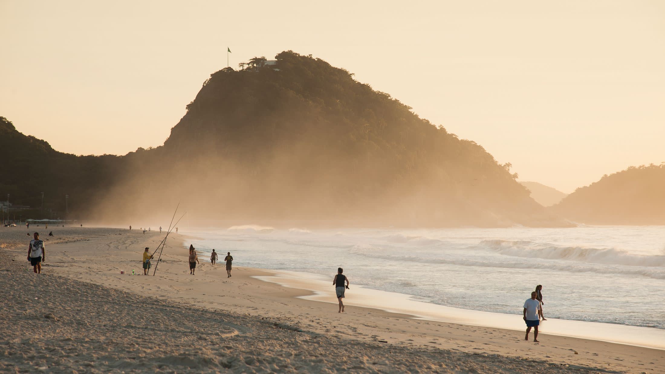 a group of people walking on a beach