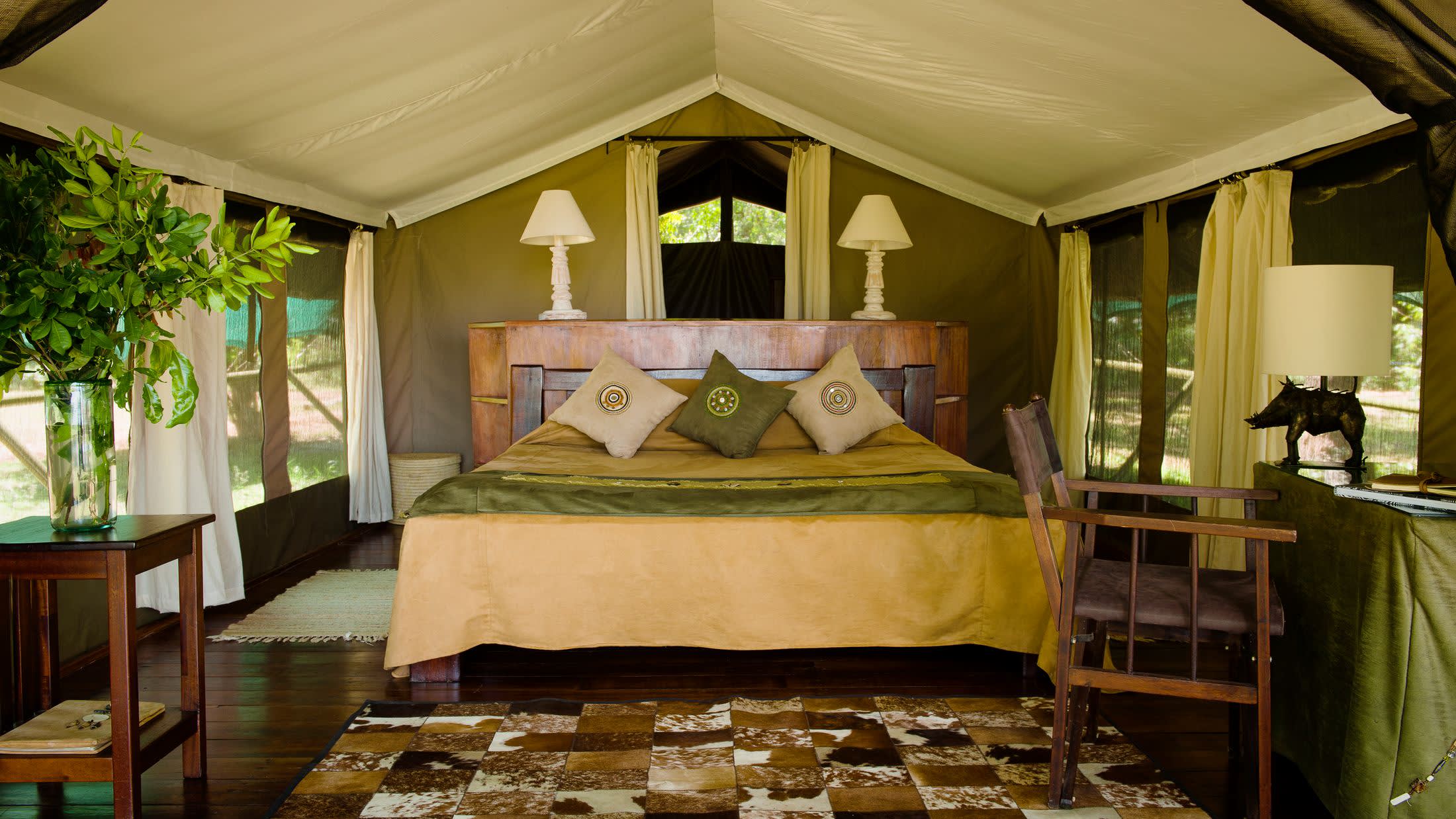 a bedroom with a bed and a chair in a room