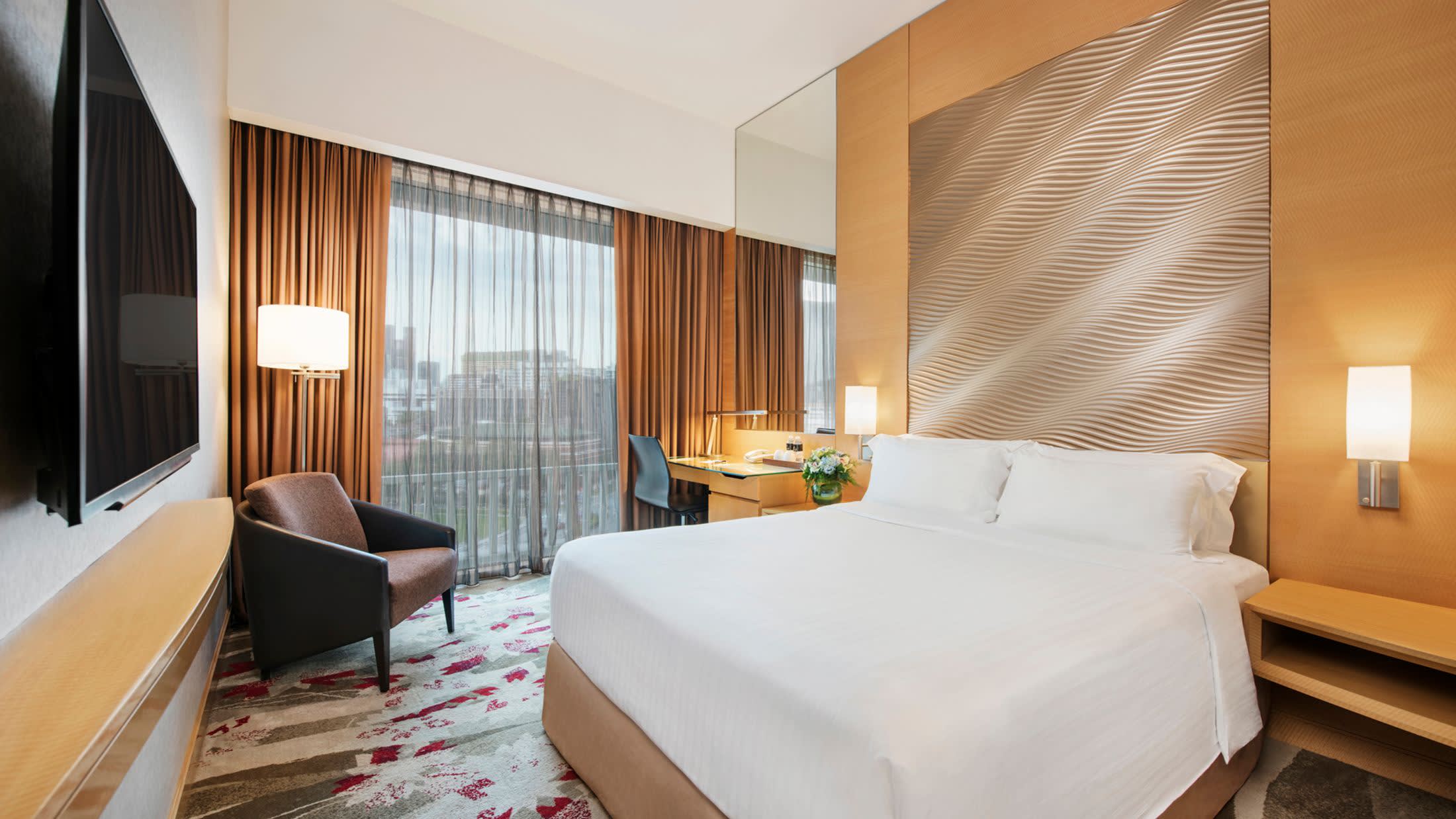 a bedroom with a bed and desk in a hotel room