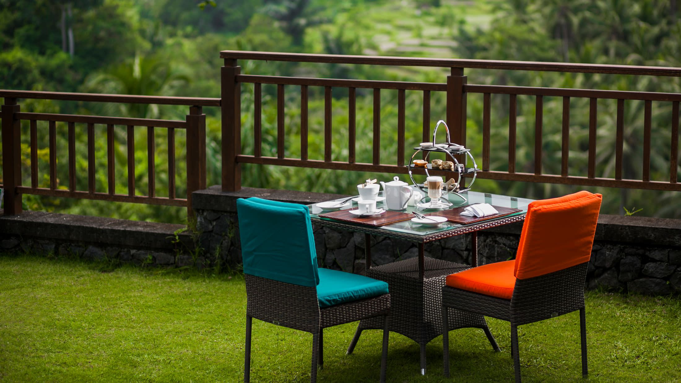 a couple of lawn chairs sitting on top of a wooden fence