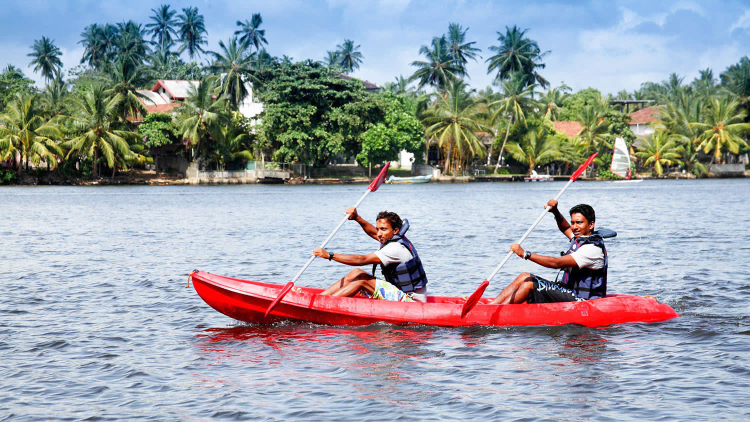 a group of people riding on the back of a boat in the water