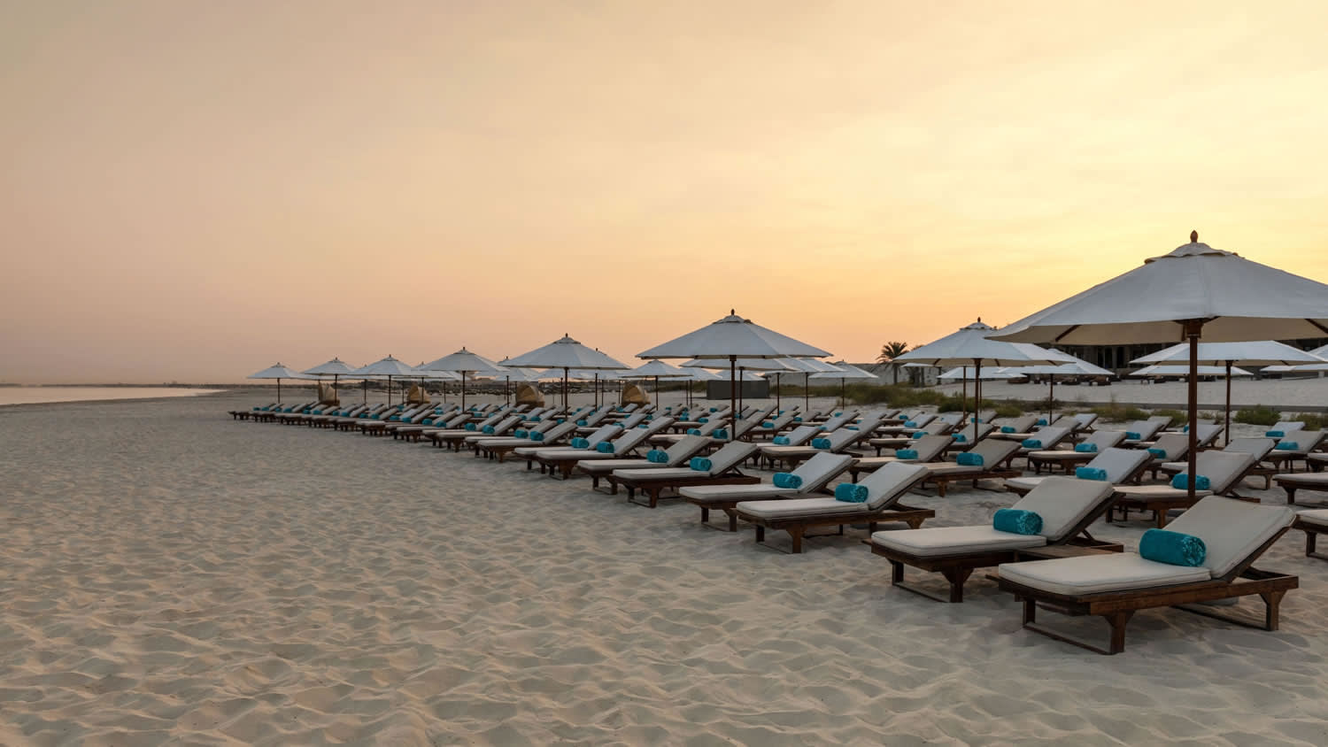 a row of beach chairs and an umbrella