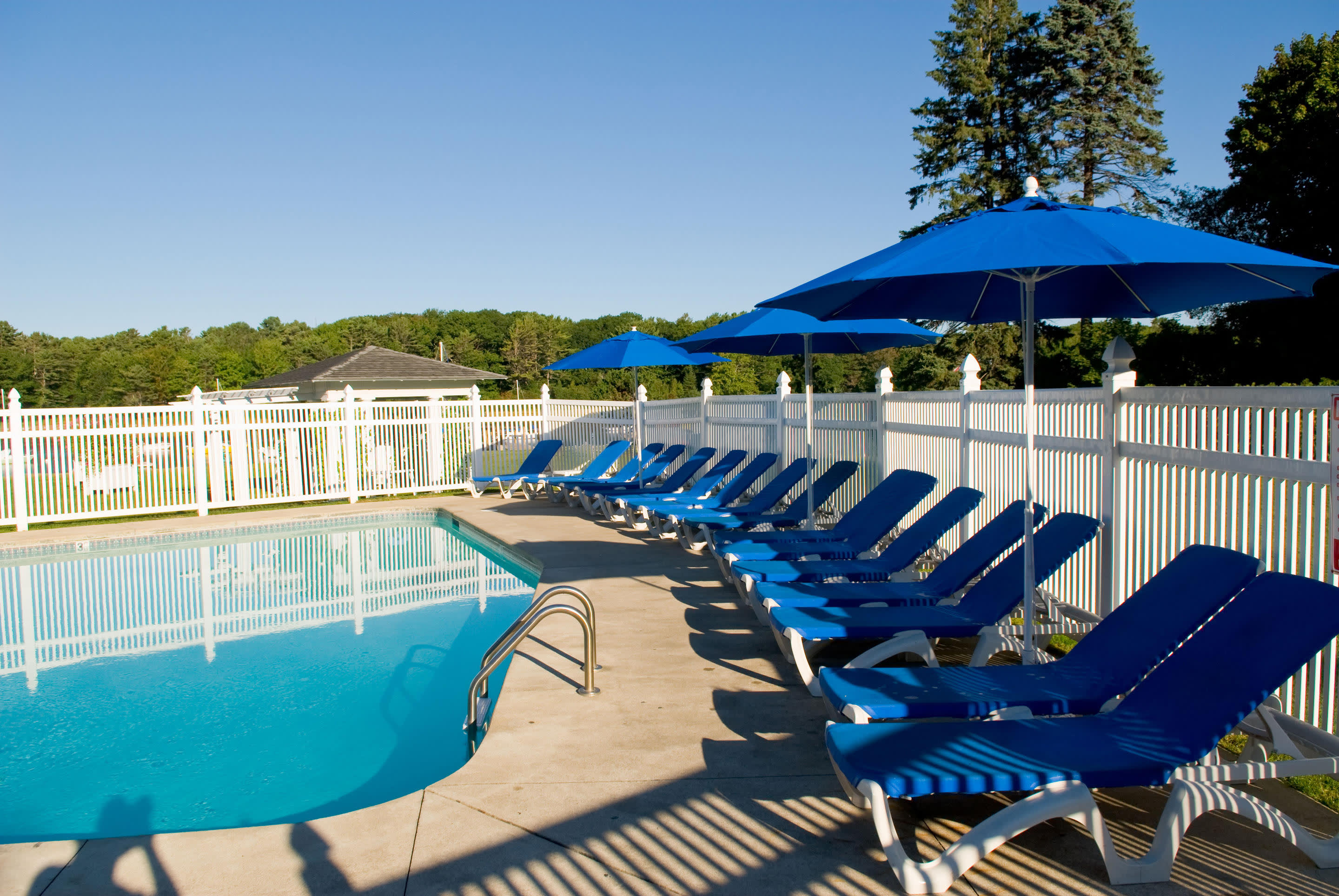 a row of lawn chairs sitting on top of a sandy beach