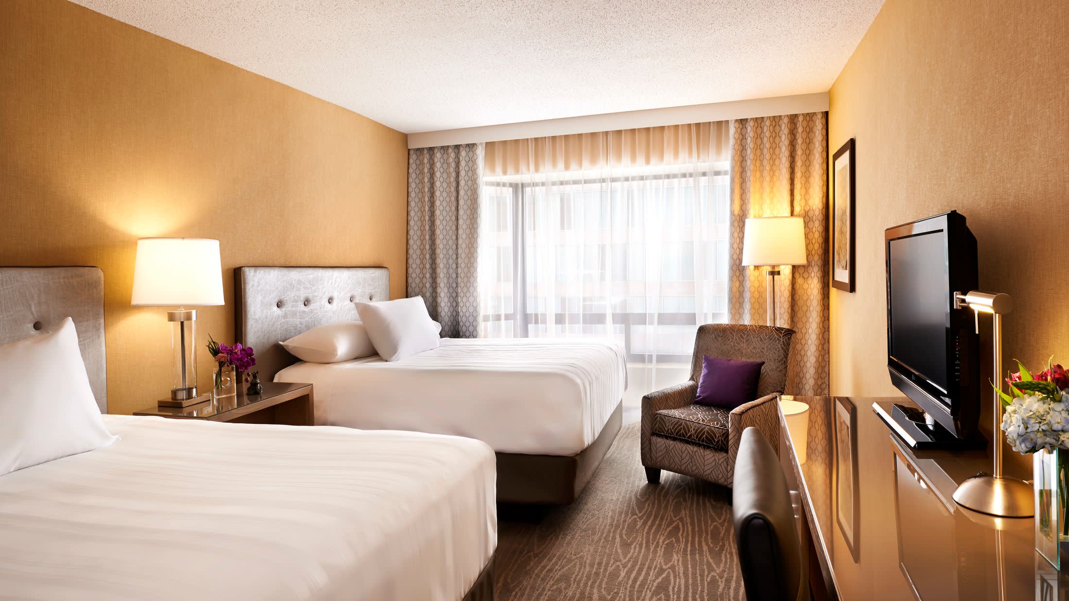 a bedroom with a bed and desk in a hotel room