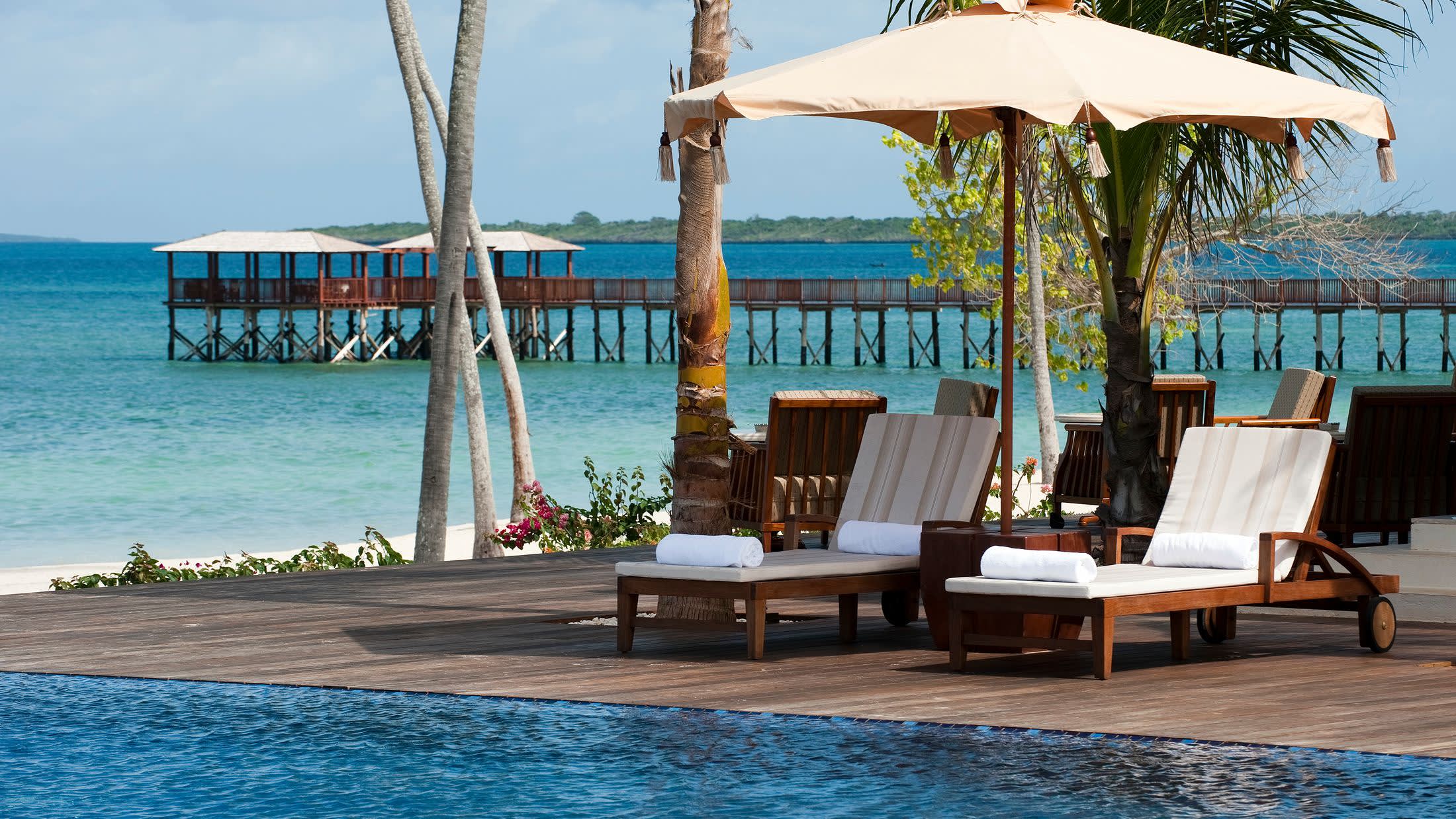 a group of lawn chairs sitting next to a pool of water