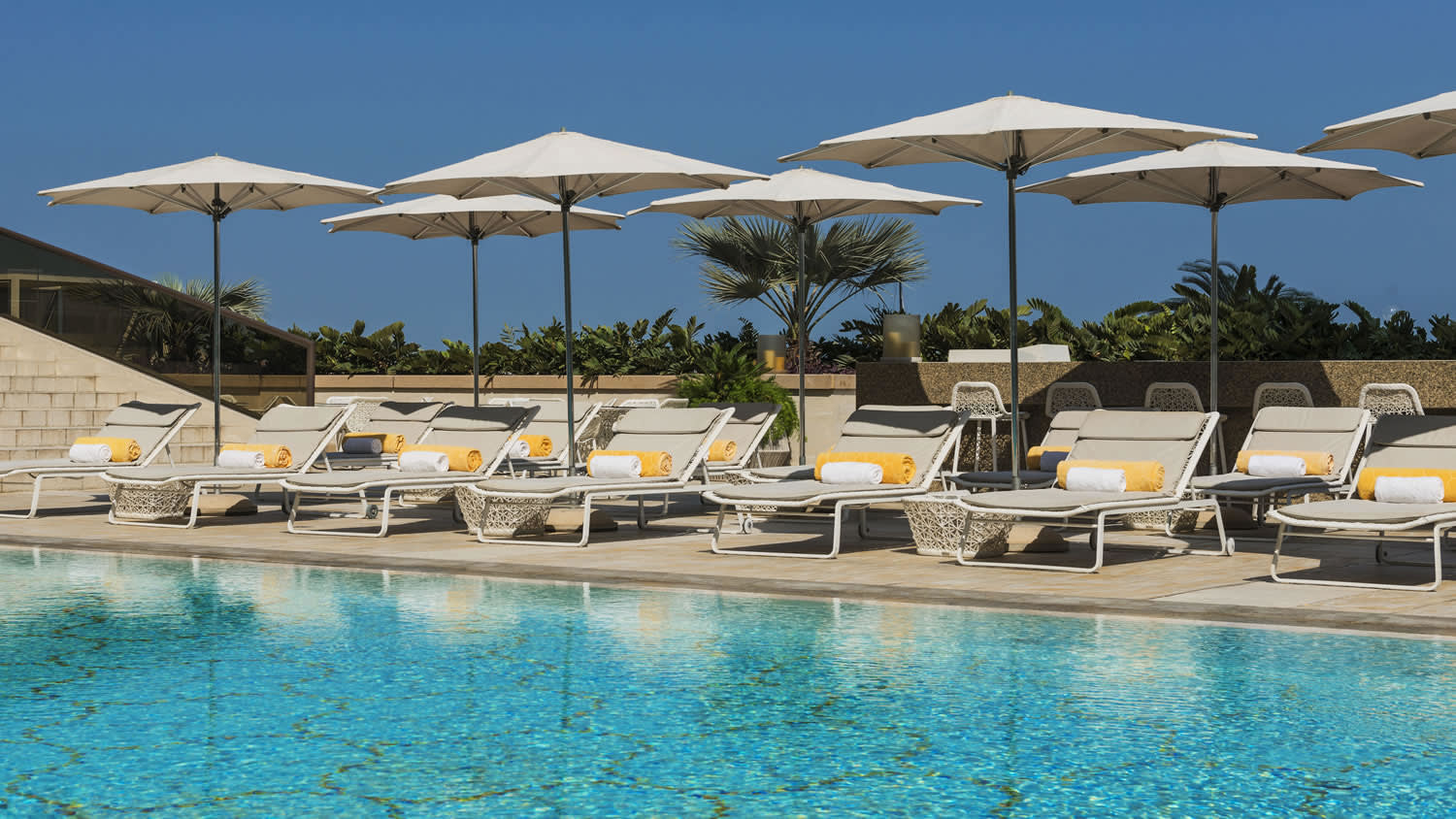 a group of lawn chairs sitting next to a pool of water