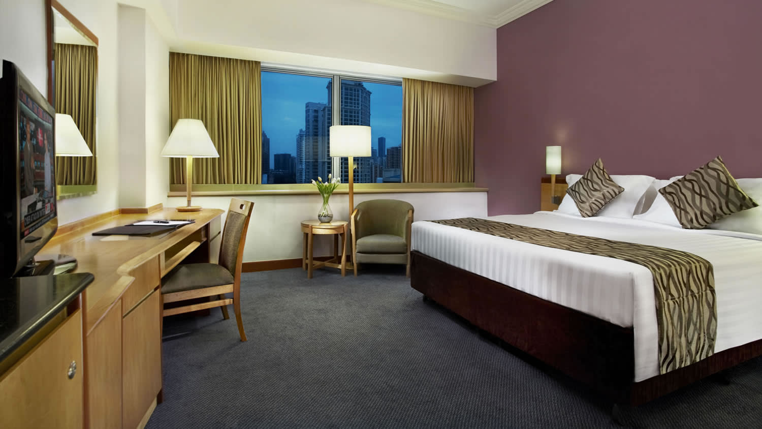 a bedroom with a bed and desk in a hotel room