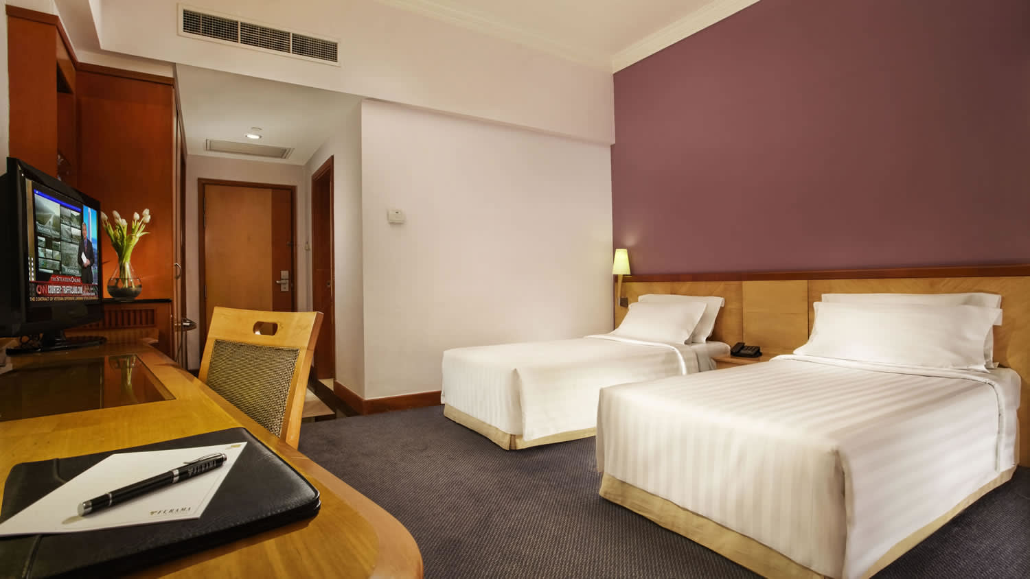 a bedroom with a bed and desk in a room