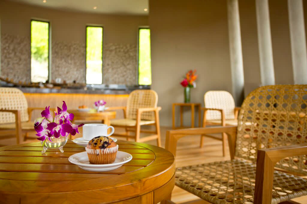 a room filled with furniture and vase of flowers on a table