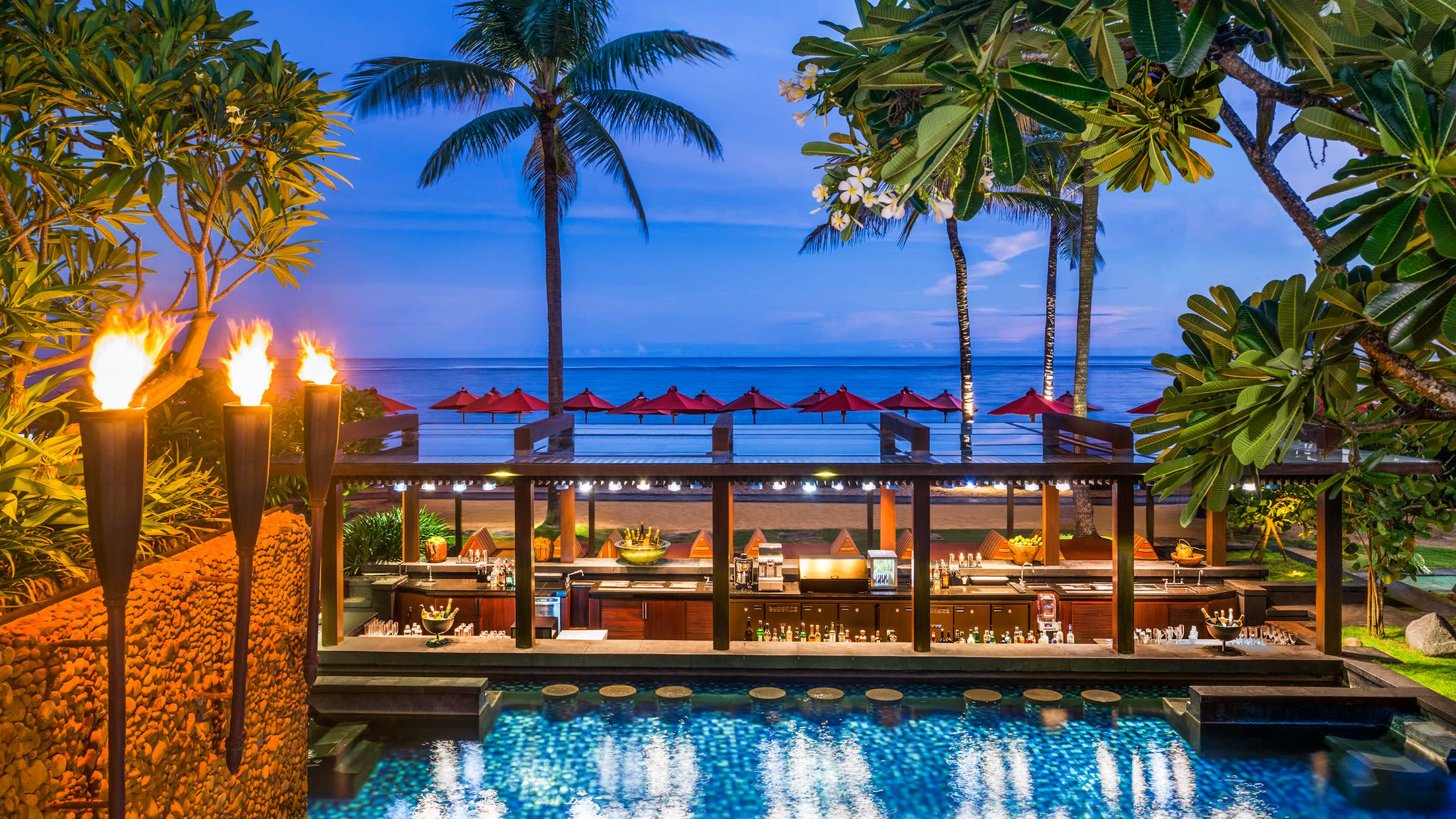 a group of palm trees next to a body of water