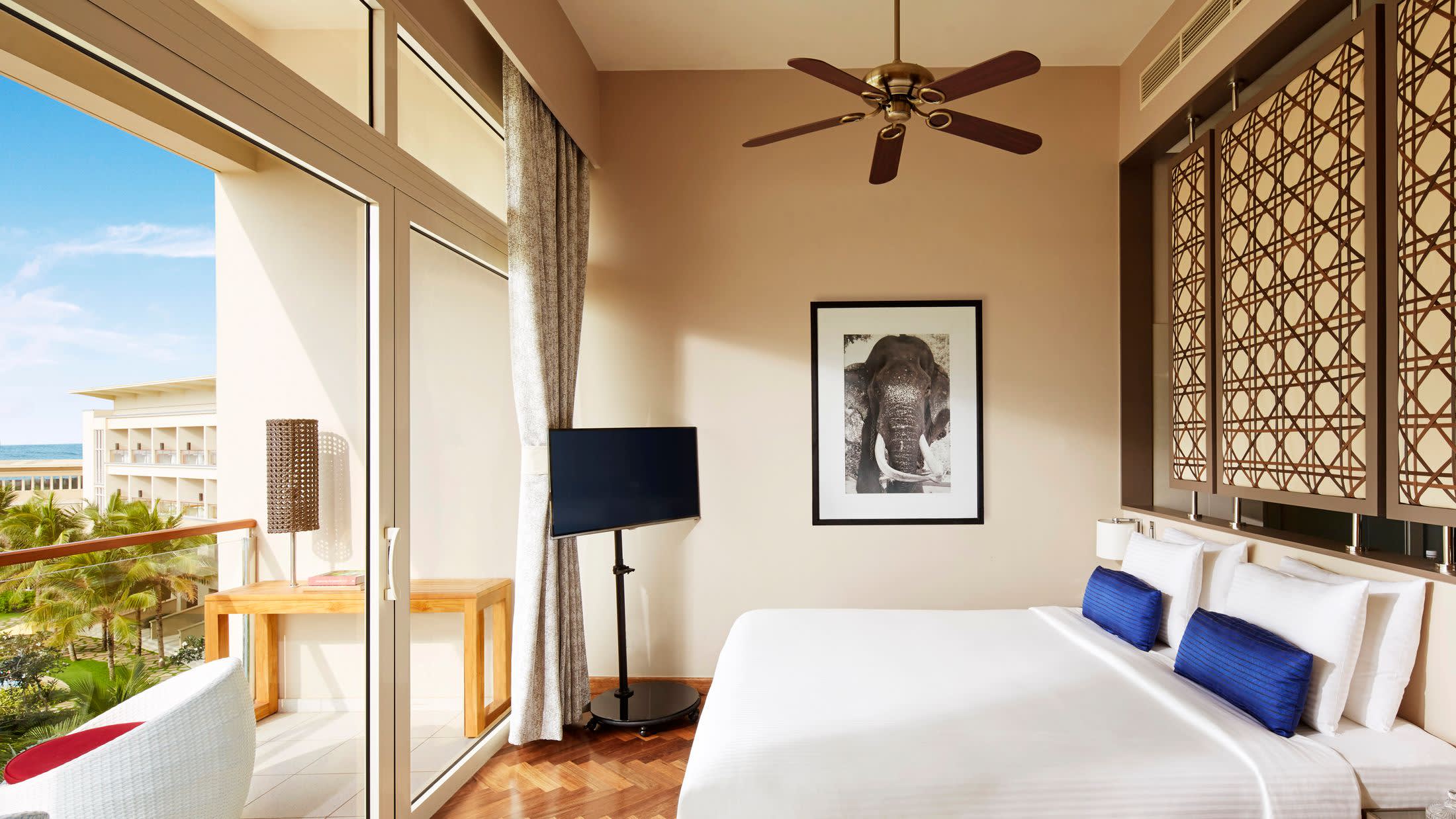 a bedroom with a bed and a chair in a room