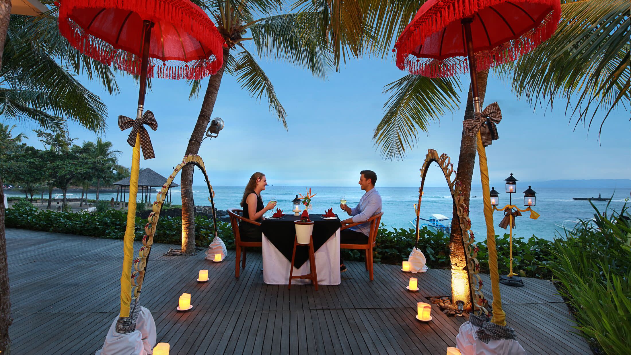 a person sitting at a table with a red umbrella
