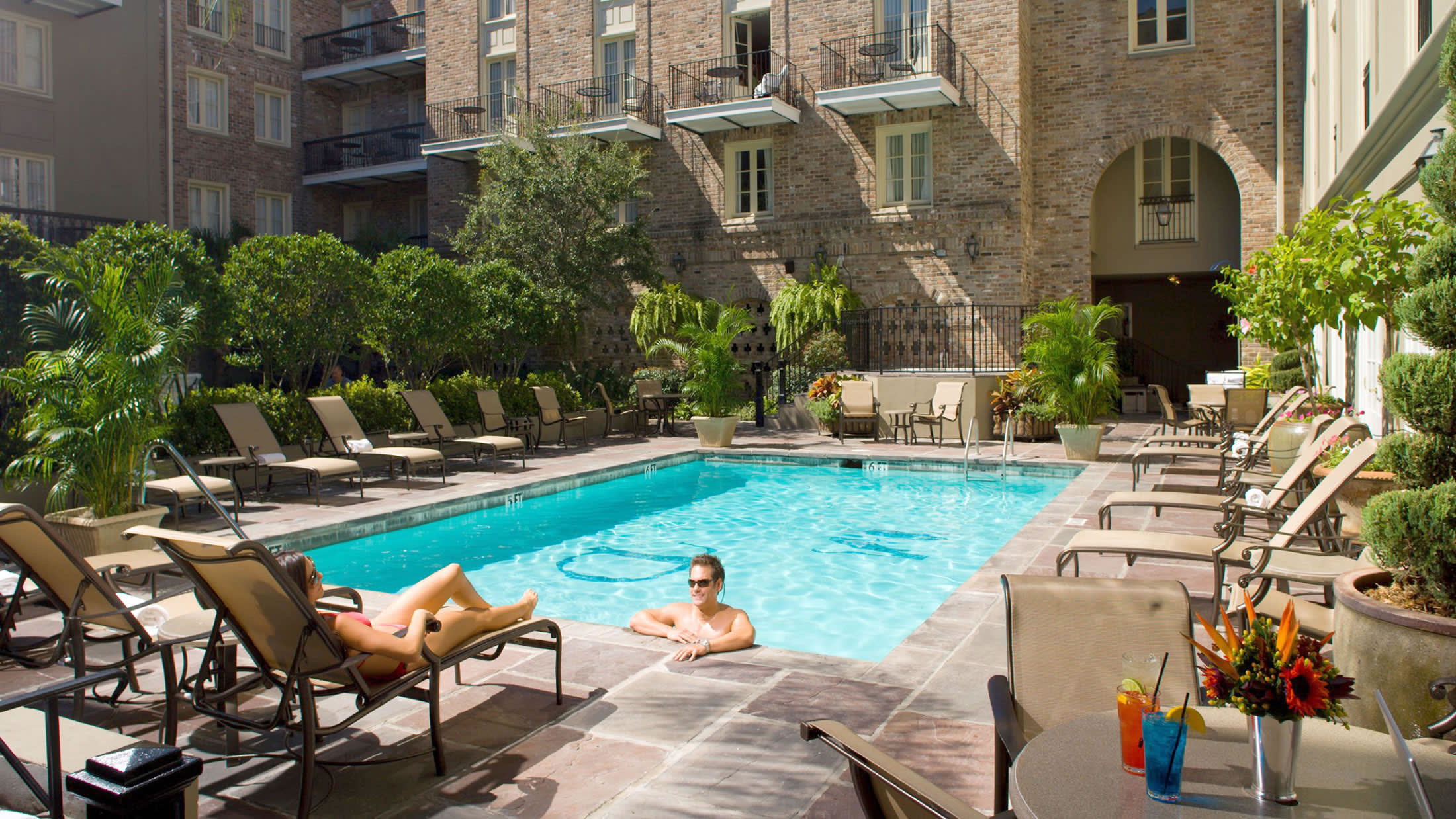 a person sitting at a table in front of a pool