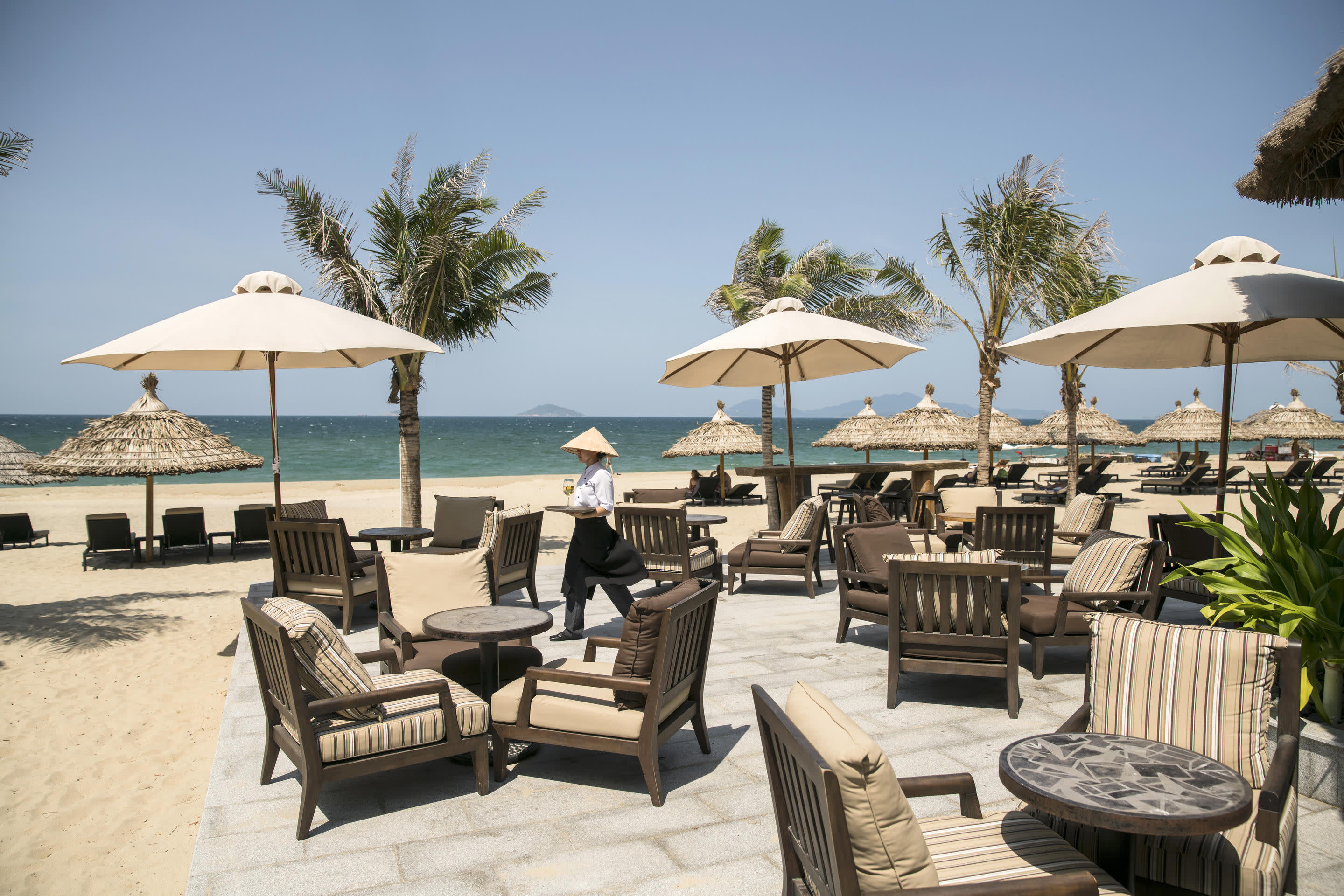 a group of lawn chairs sitting on top of a sandy beach
