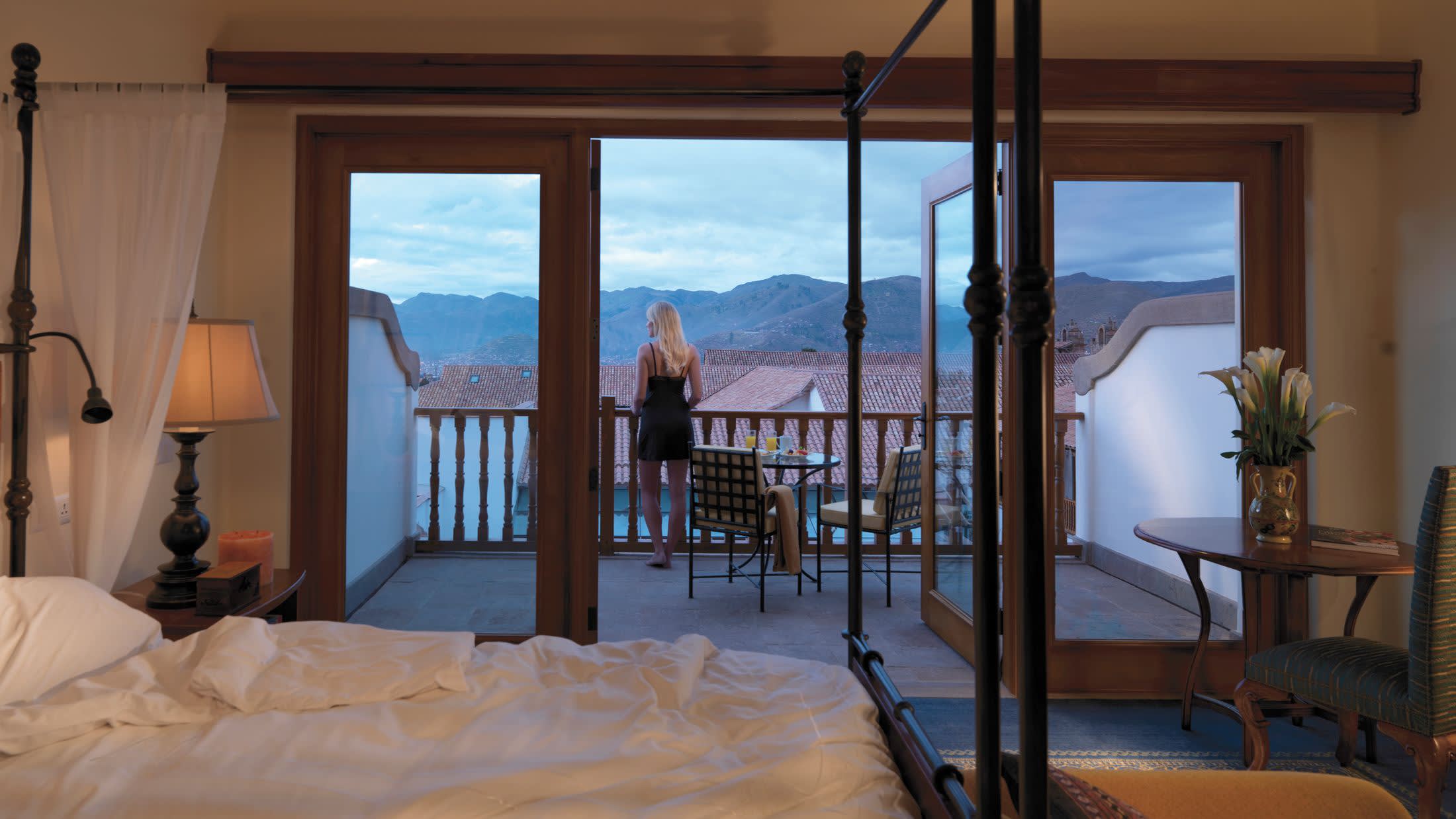 a bedroom with a bed and a chair in front of a window
