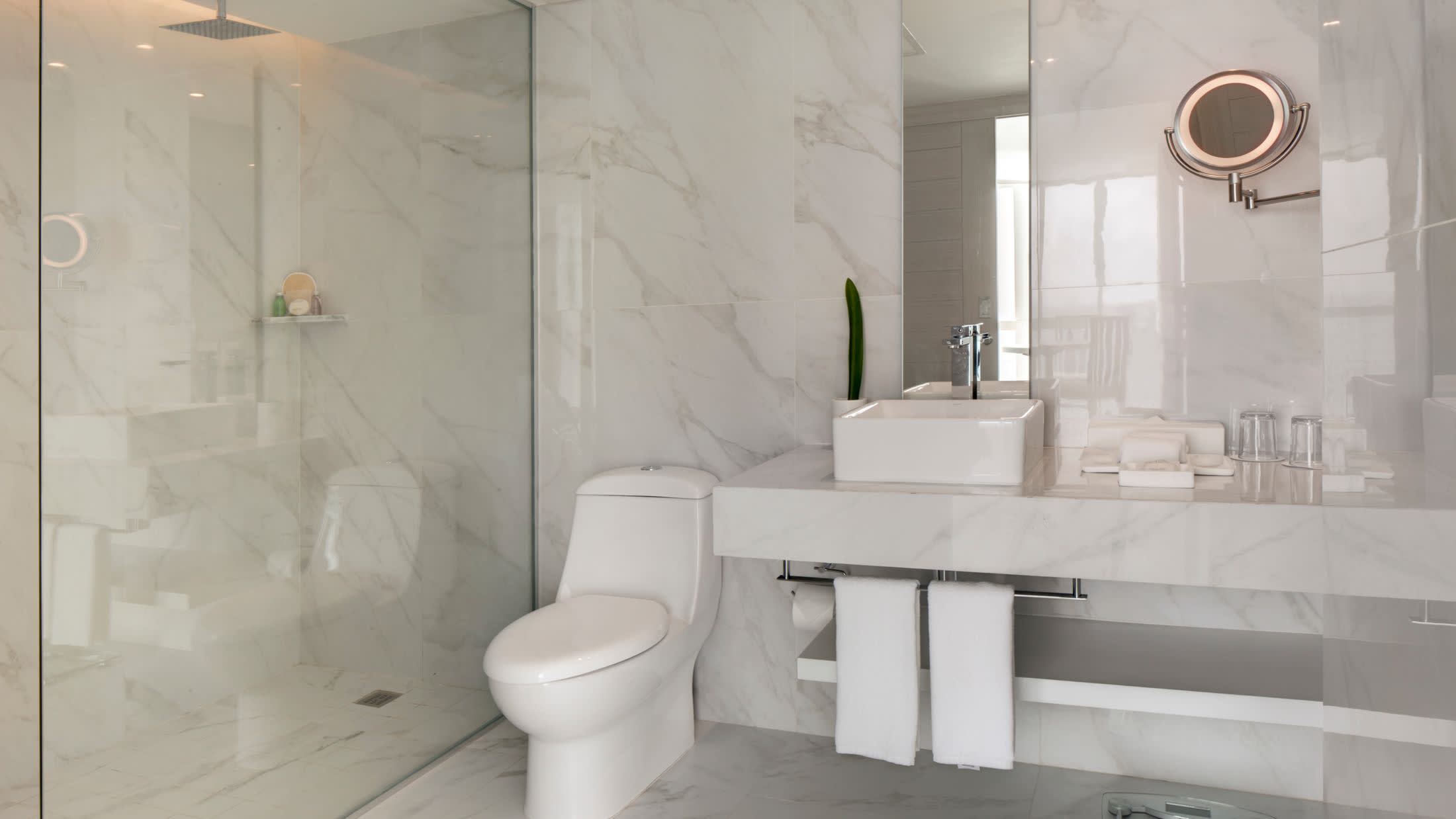a white sink sitting under a mirror