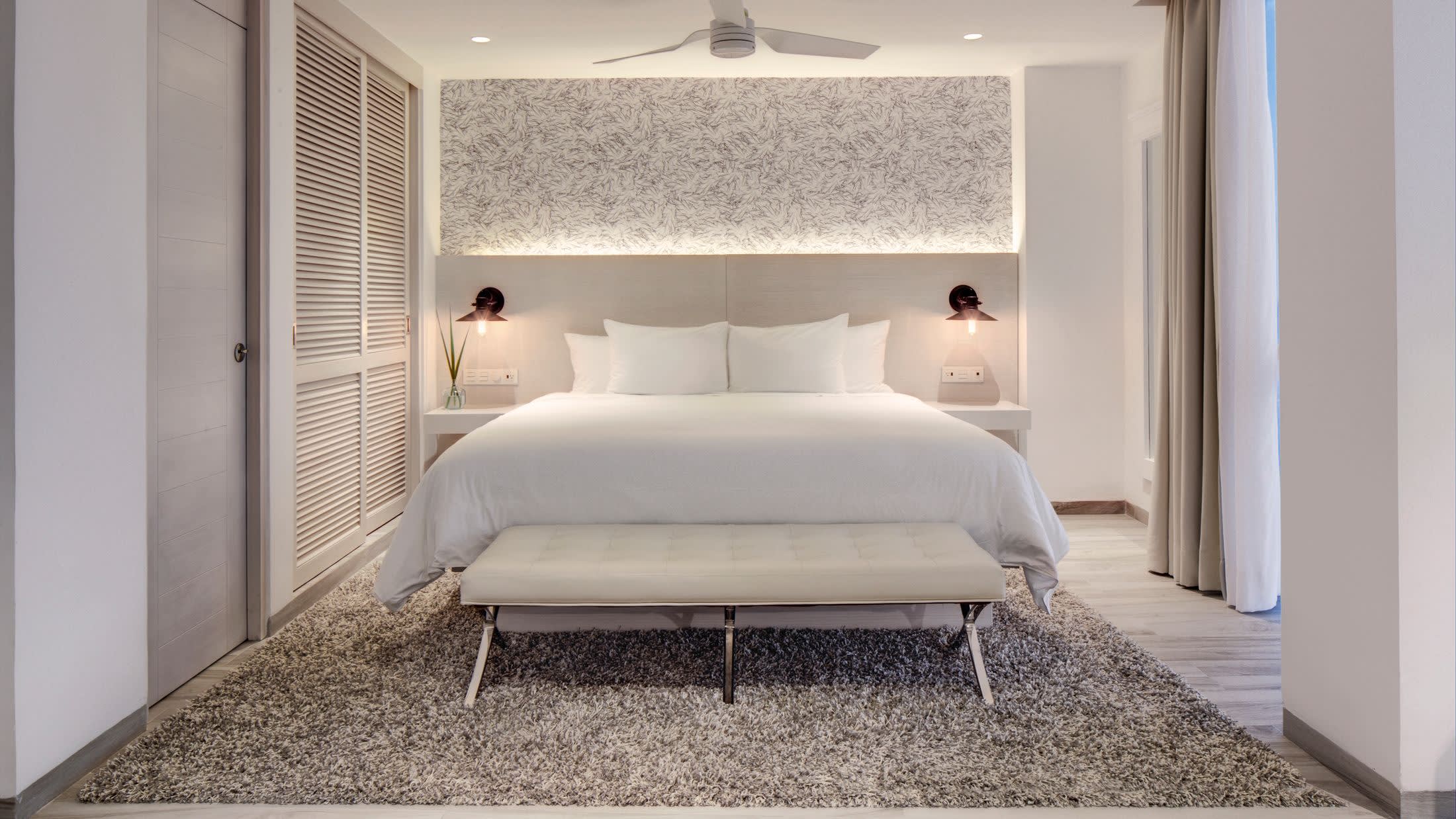 a large white bed sitting next to a window