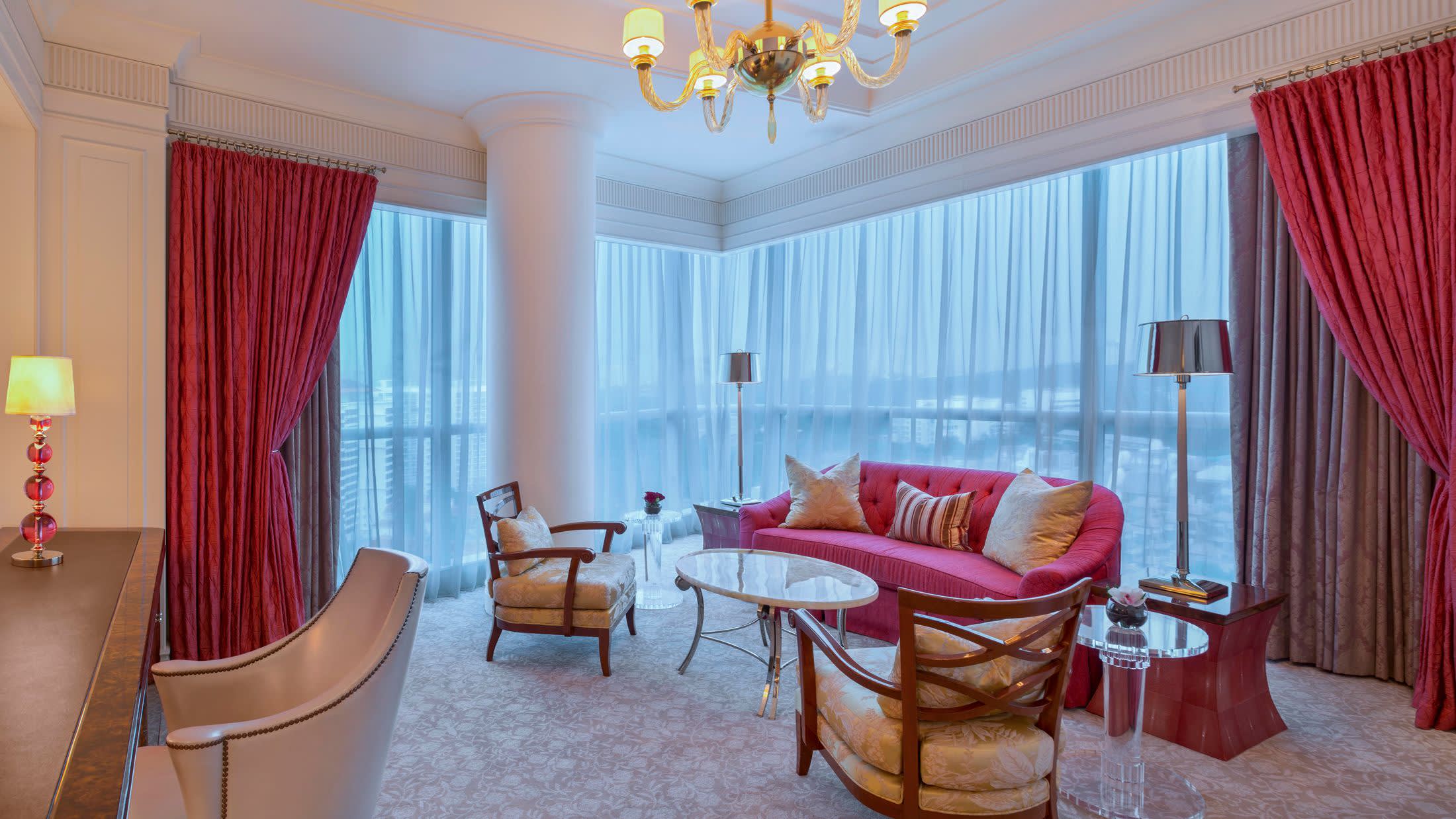 a living room filled with furniture and a red curtain