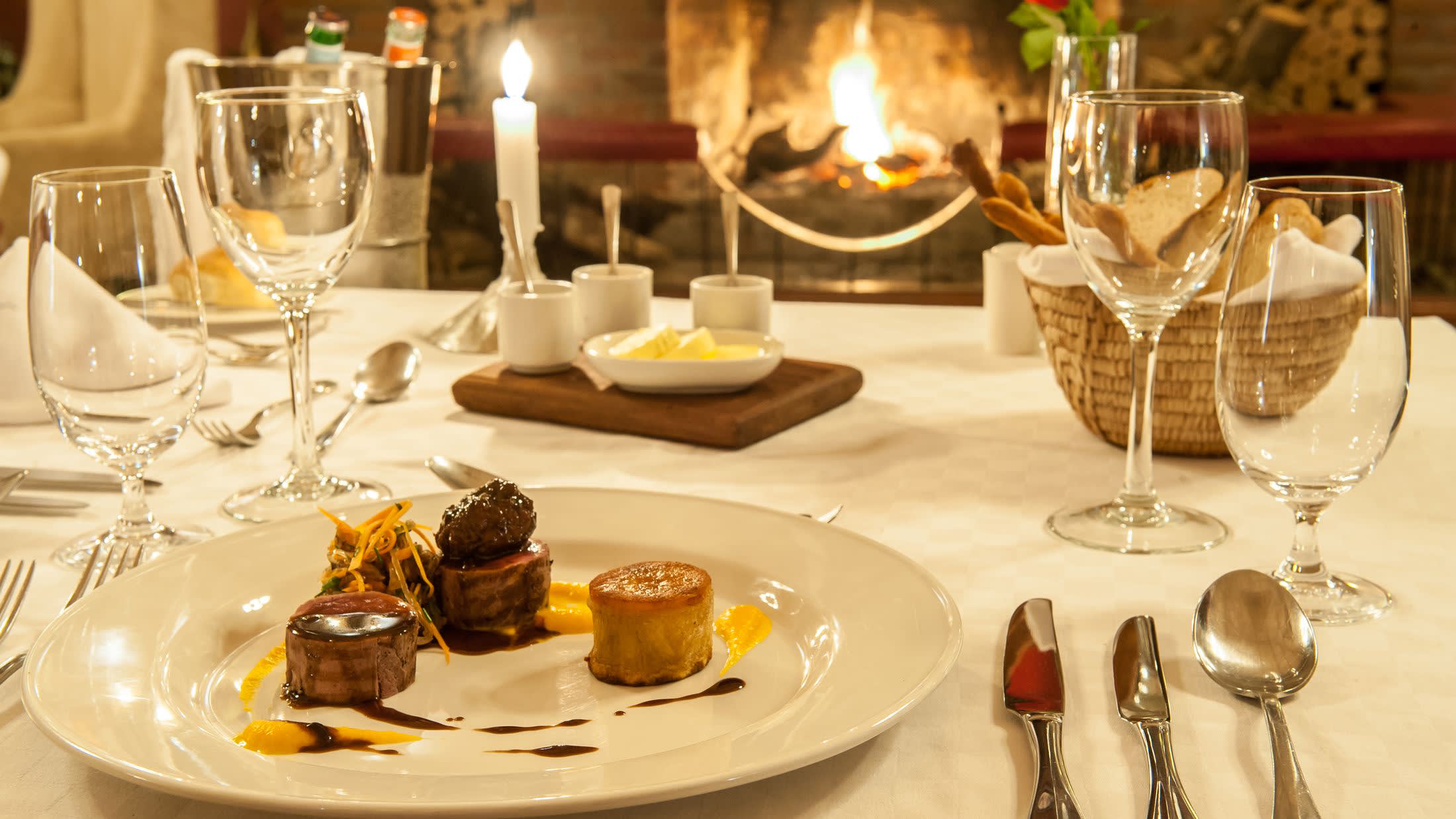 a plate of food and glasses of wine on a table