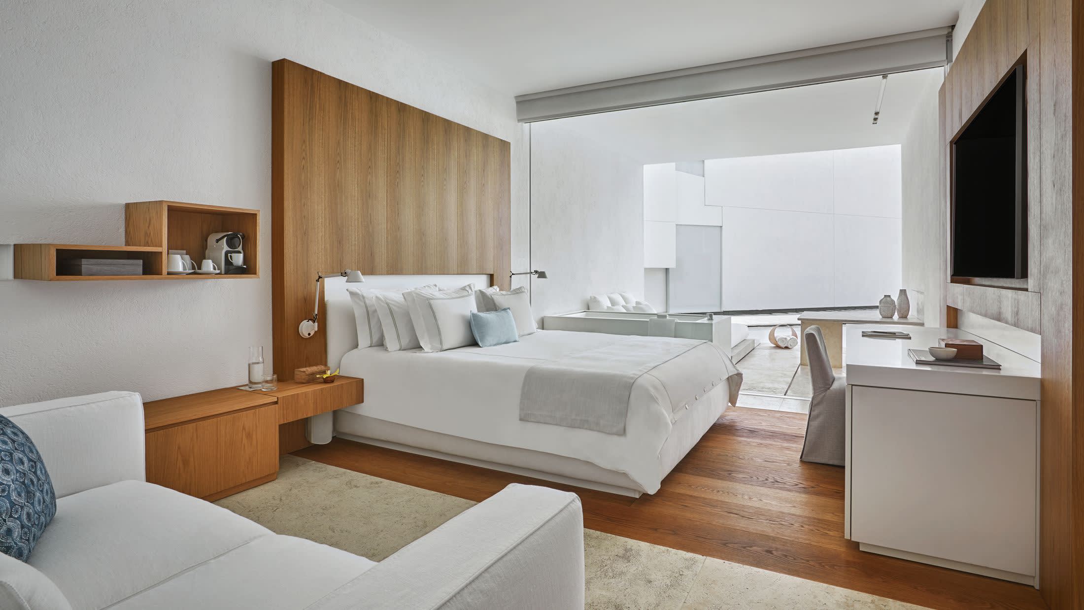 a bedroom with a bed and a mirror in a room